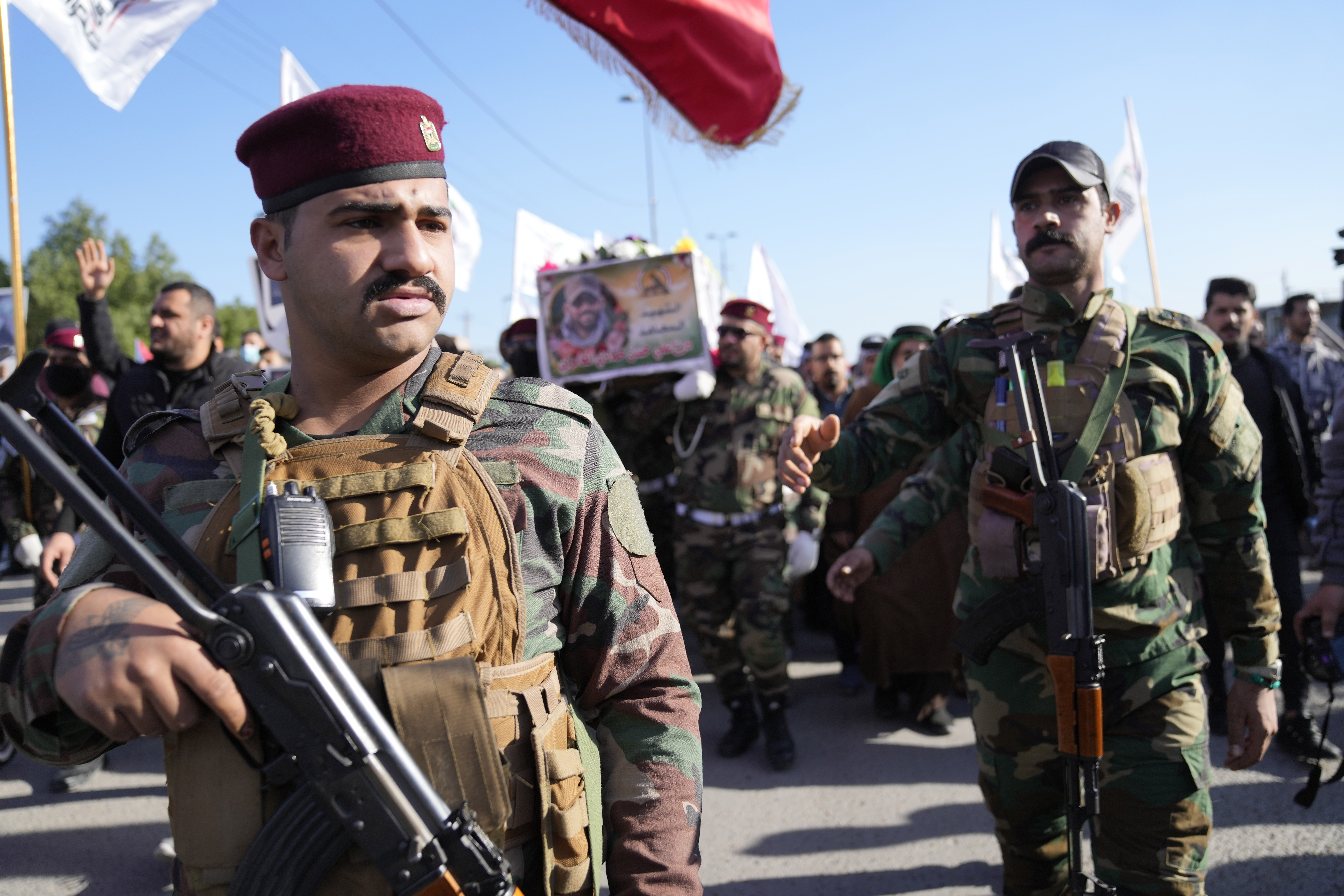 Members of an Iraqi Shiite militant group carry the coffin of an fighter with the Kataib Hezbollah militia, who was killed in a U.S. airstrike in Babil Province, during his funeral in Baghdad, Iraq, Tuesday, Dec. 26, 2023. (AP Photo/Hadi Mizban)