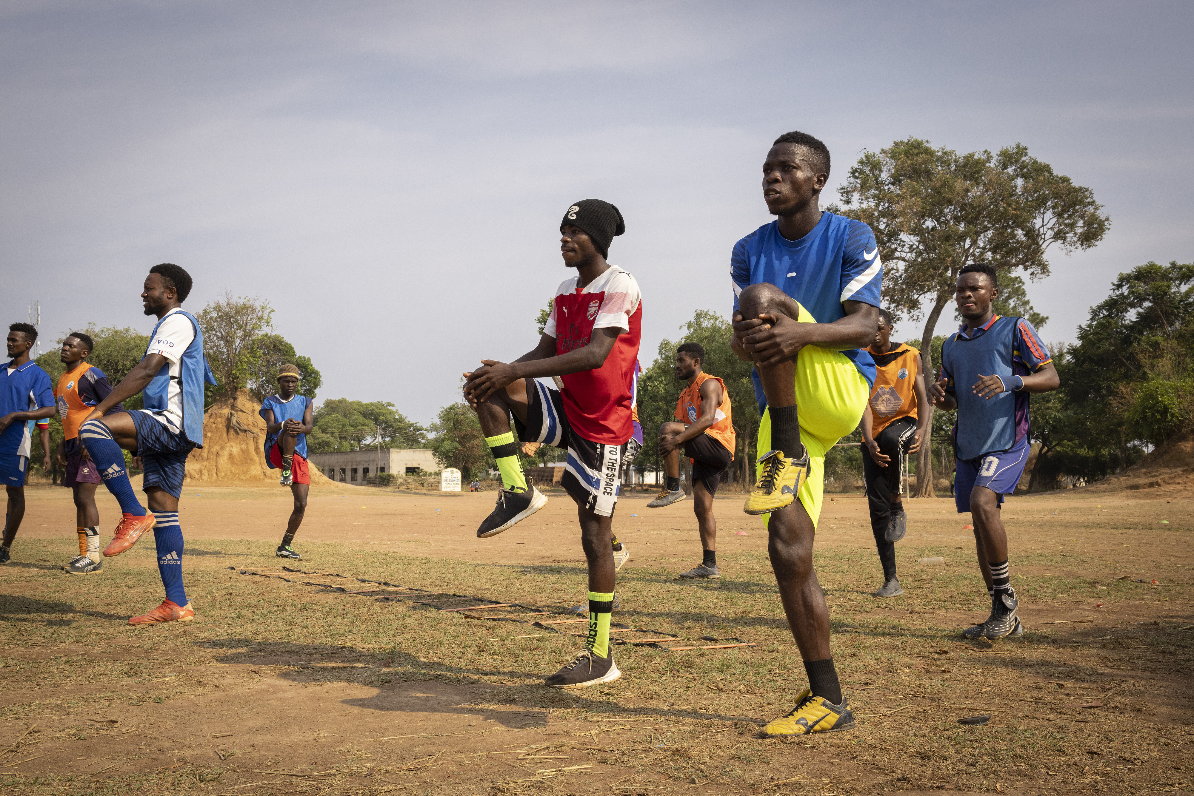 Football players train on a field in a refugee camp in Zambia