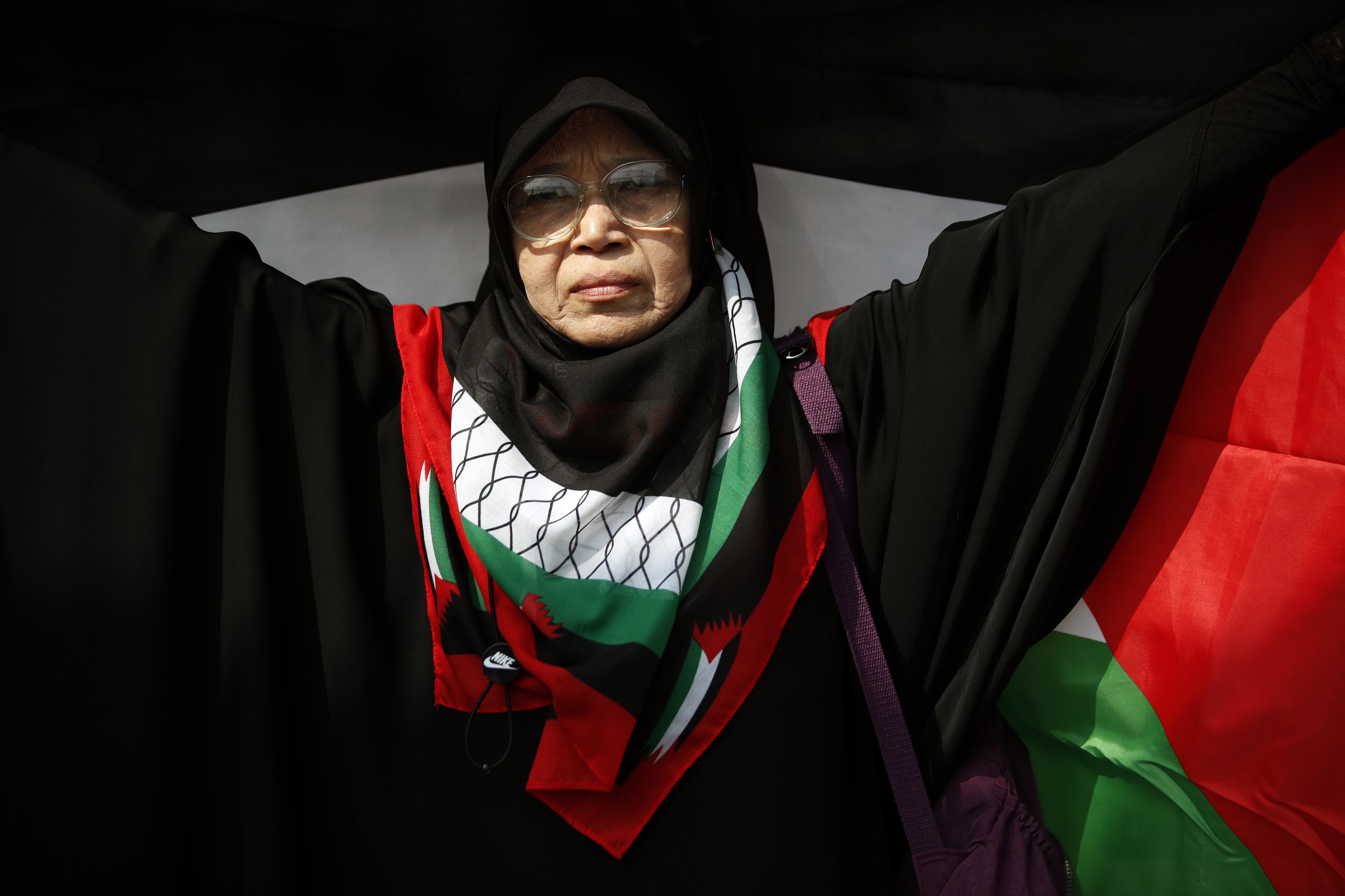 A Thai-Muslim demonstrator holds a large Palestinian flag during a protest calling for a permanent ceasefire in the Gaza Strip to mark the Global Day of Action for Gaza at the US embassy in Bangkok