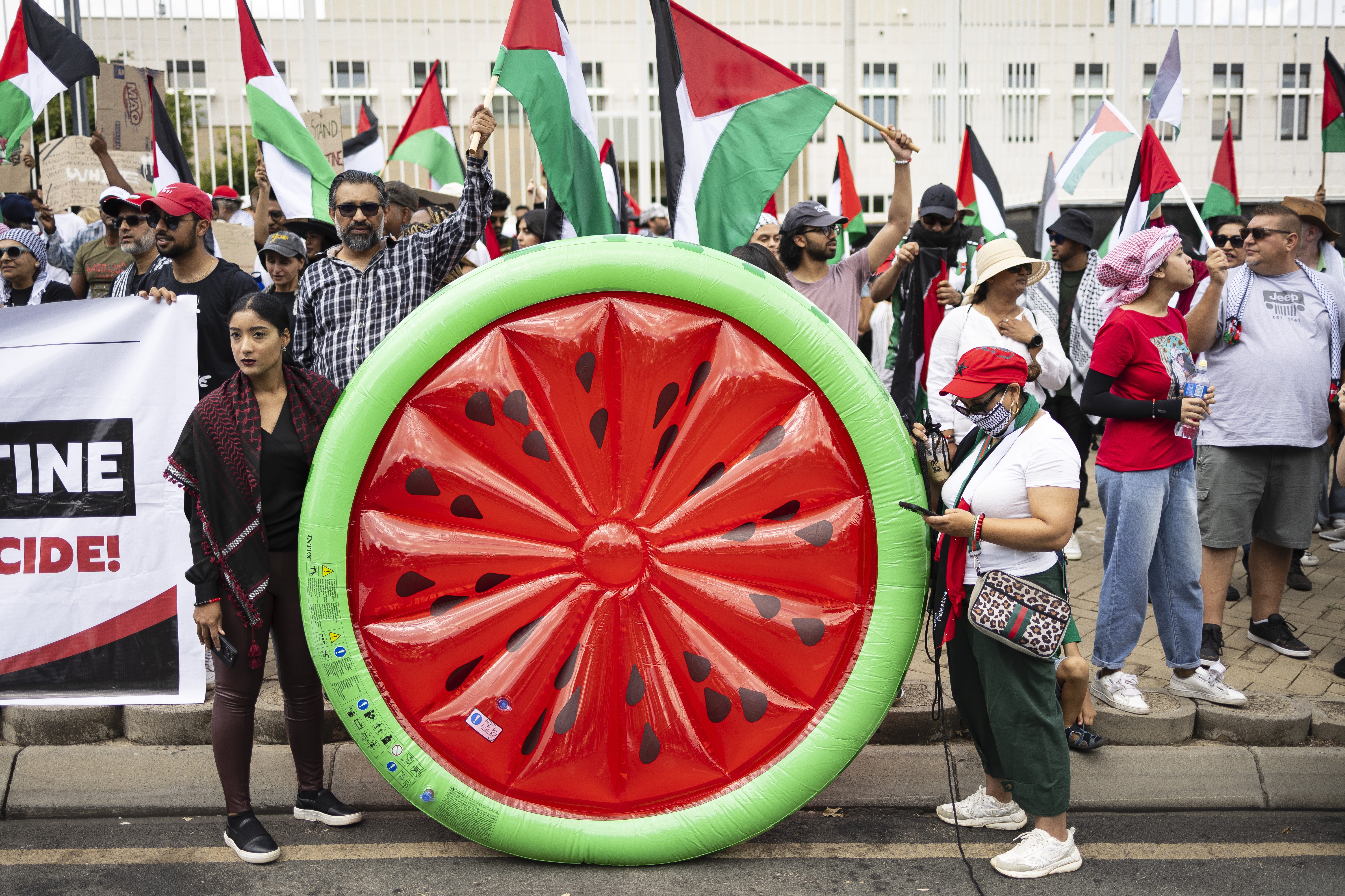 Protestors wave flags during a free Palestine protest at the United States Consulate as part of a global day of action in support of a free Palestine, in Johannesburg, South Africa, 13 January