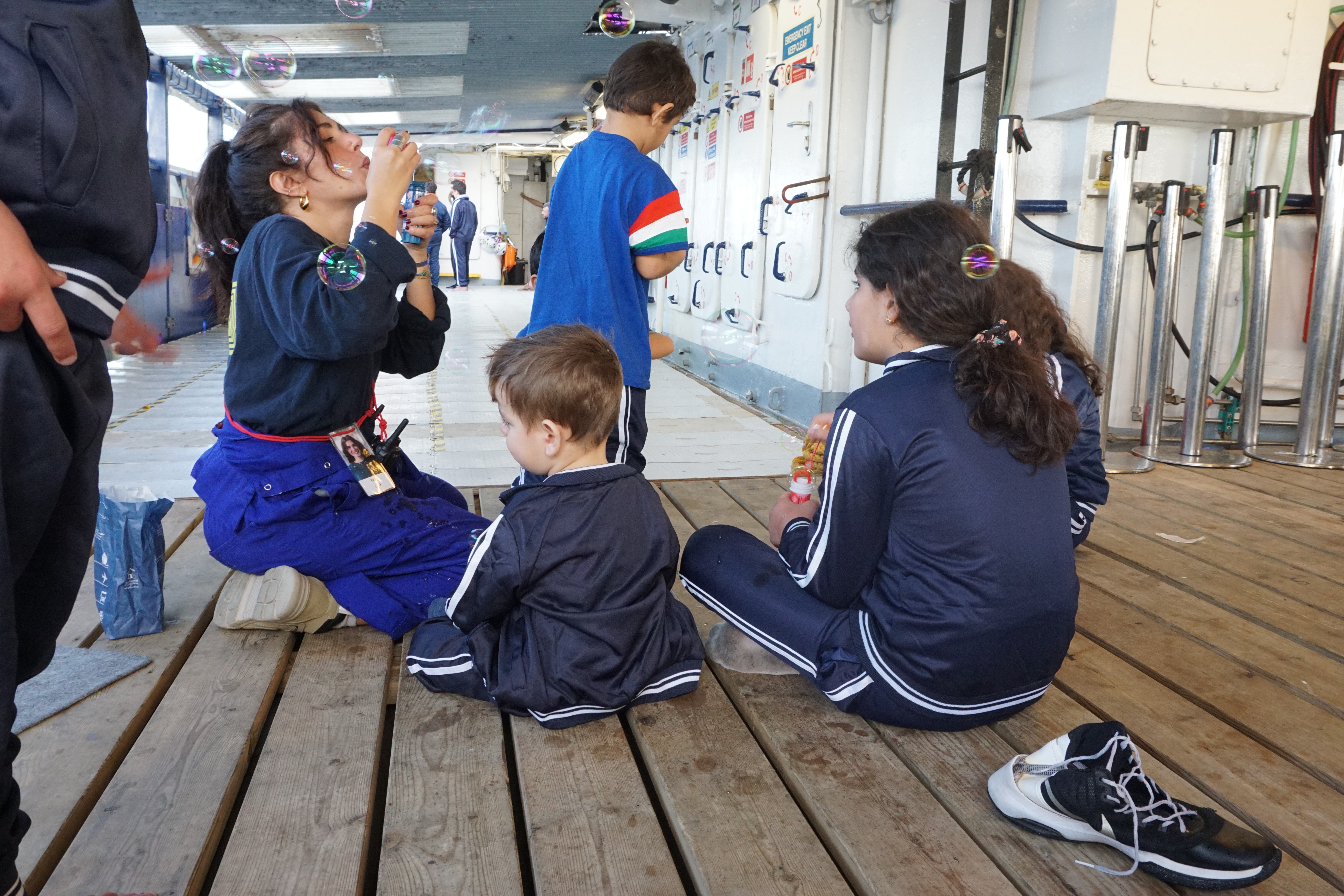 Kids playing while their moms see the ship doctor