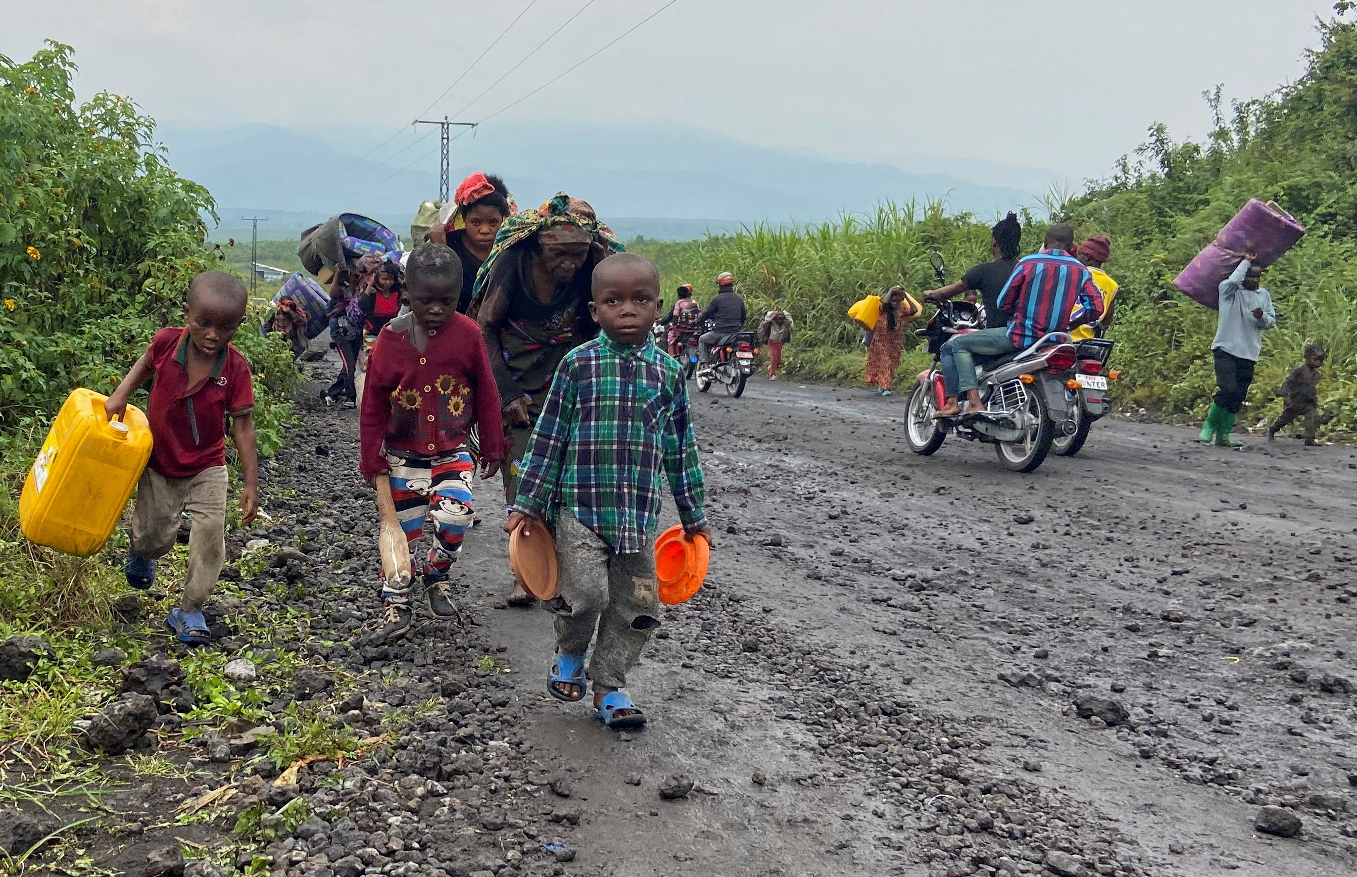 FILE PHOTO: Civilians carry their belongings as they flee after heavy gunfire that raised fears of M23 rebels advancing along a road from Sake near Goma in the North Kivu province of the Democratic Republic of Congo February 9, 2023. REUTERS/Djaffar Sabiti/File Photo