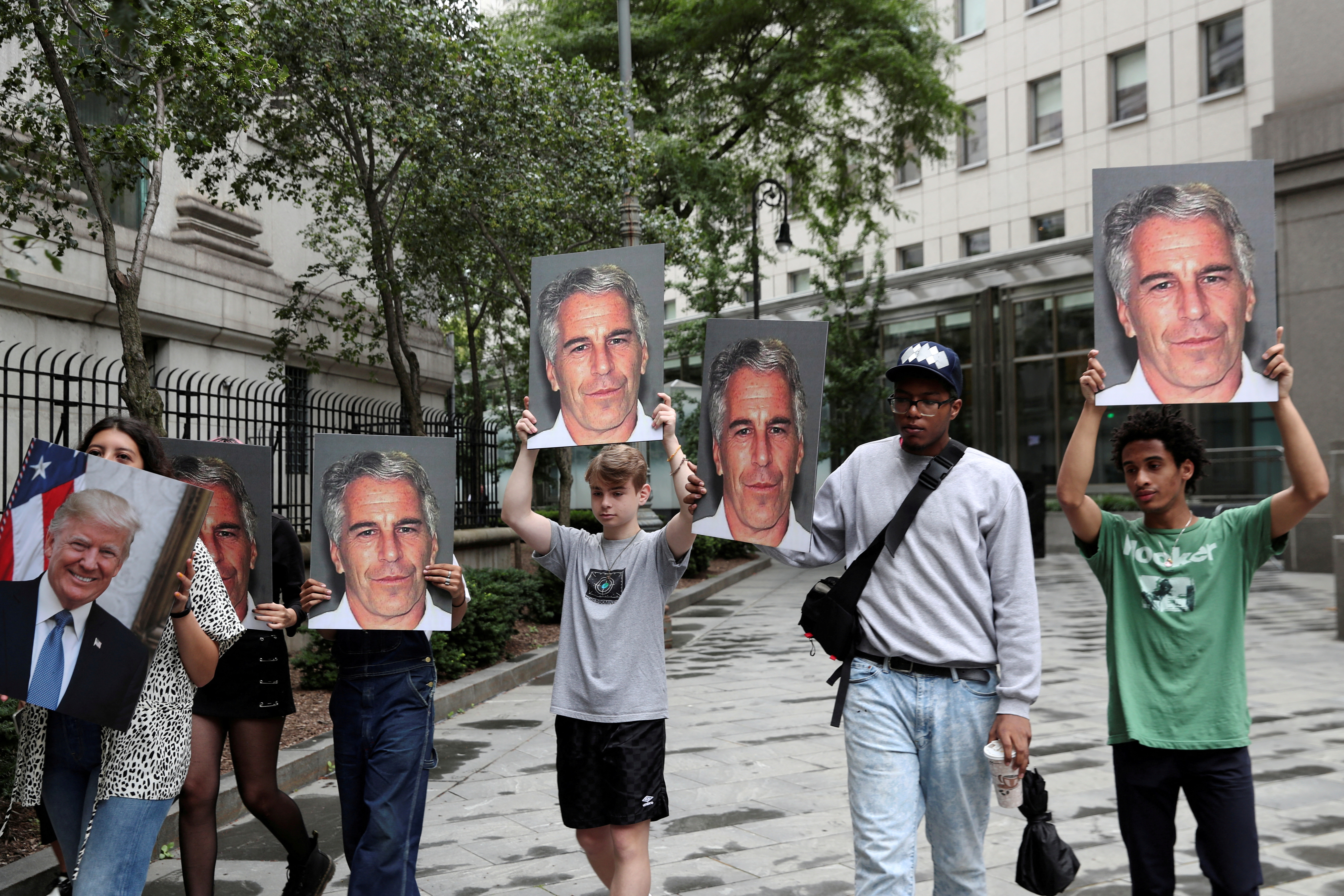 Protesters outside a court in New York where Jeffrey Epstein was facing sex trafficking charges in 2019. They are holding up placards showing his face