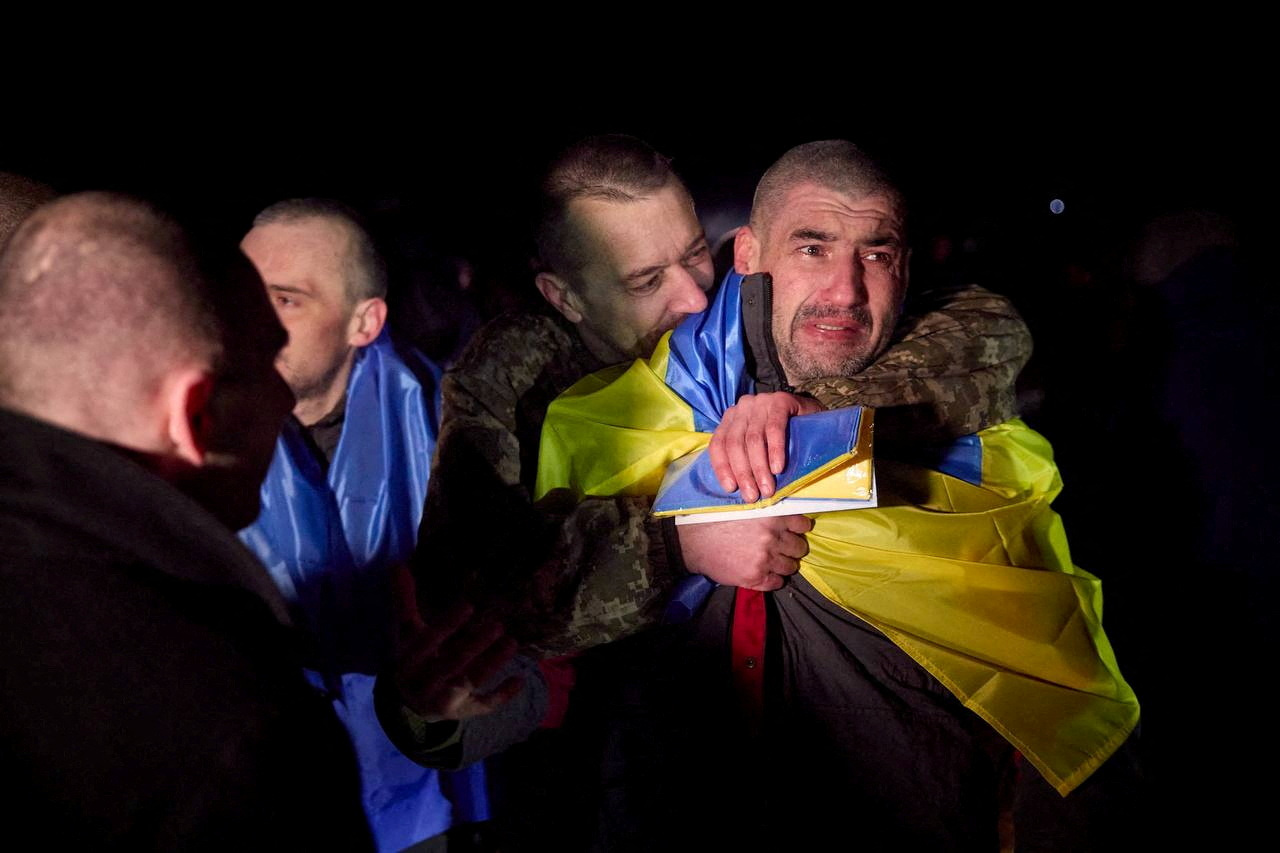 Ukrainian prisoners of war (POWs) react after a swap, amid Russia's attack on Ukraine, at an unknown location in Ukraine, in this handout picture released January 3