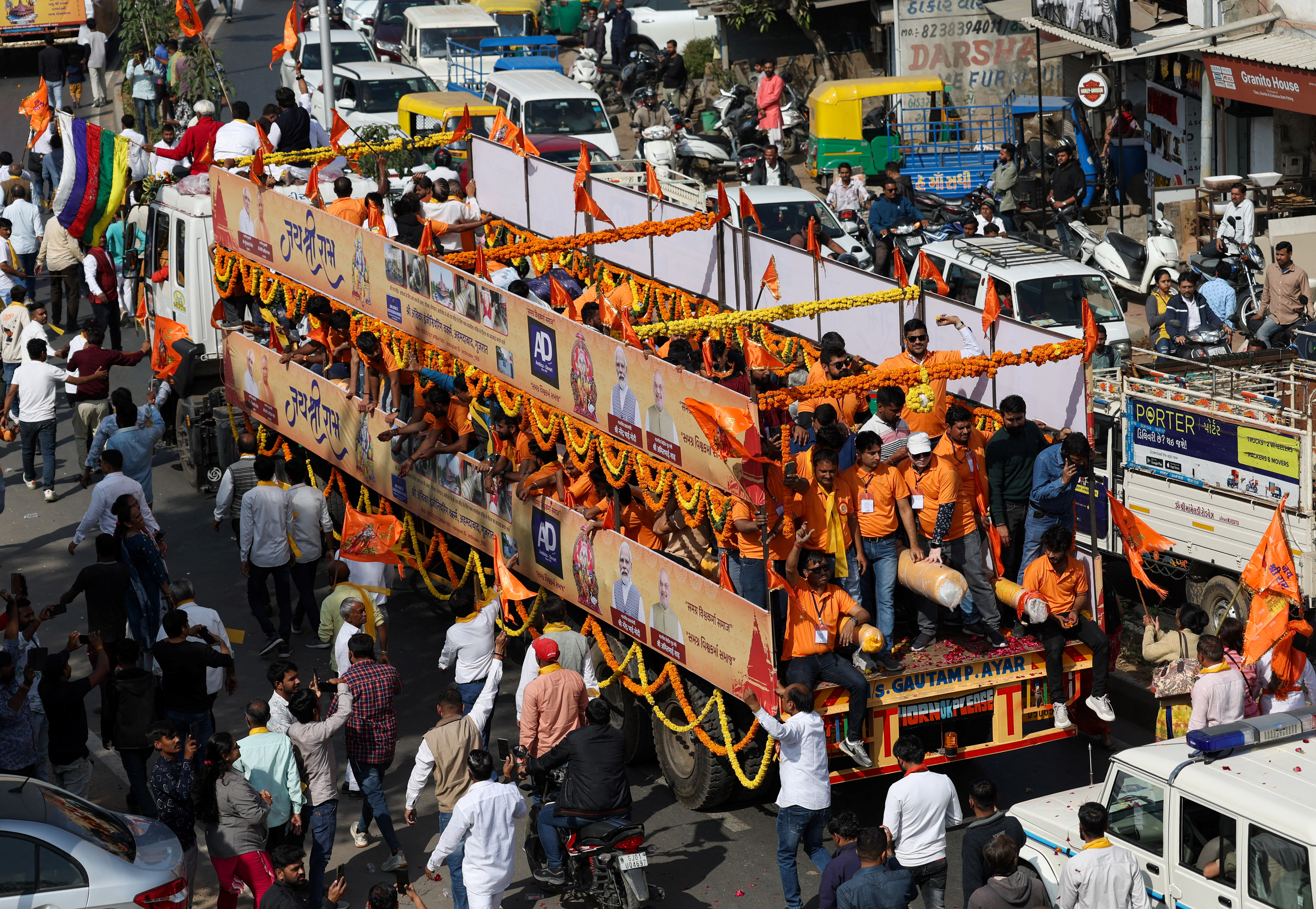 Hindu devotees transport flag poles expected to be installed at the Hindu Ram Temple in the northern town of Ayodhya ahead of the temple's inauguration ceremony, in a decorated truck trailer through a street in Ahmedabad, India, January 5, 2024. REUTERS/Amit Dave