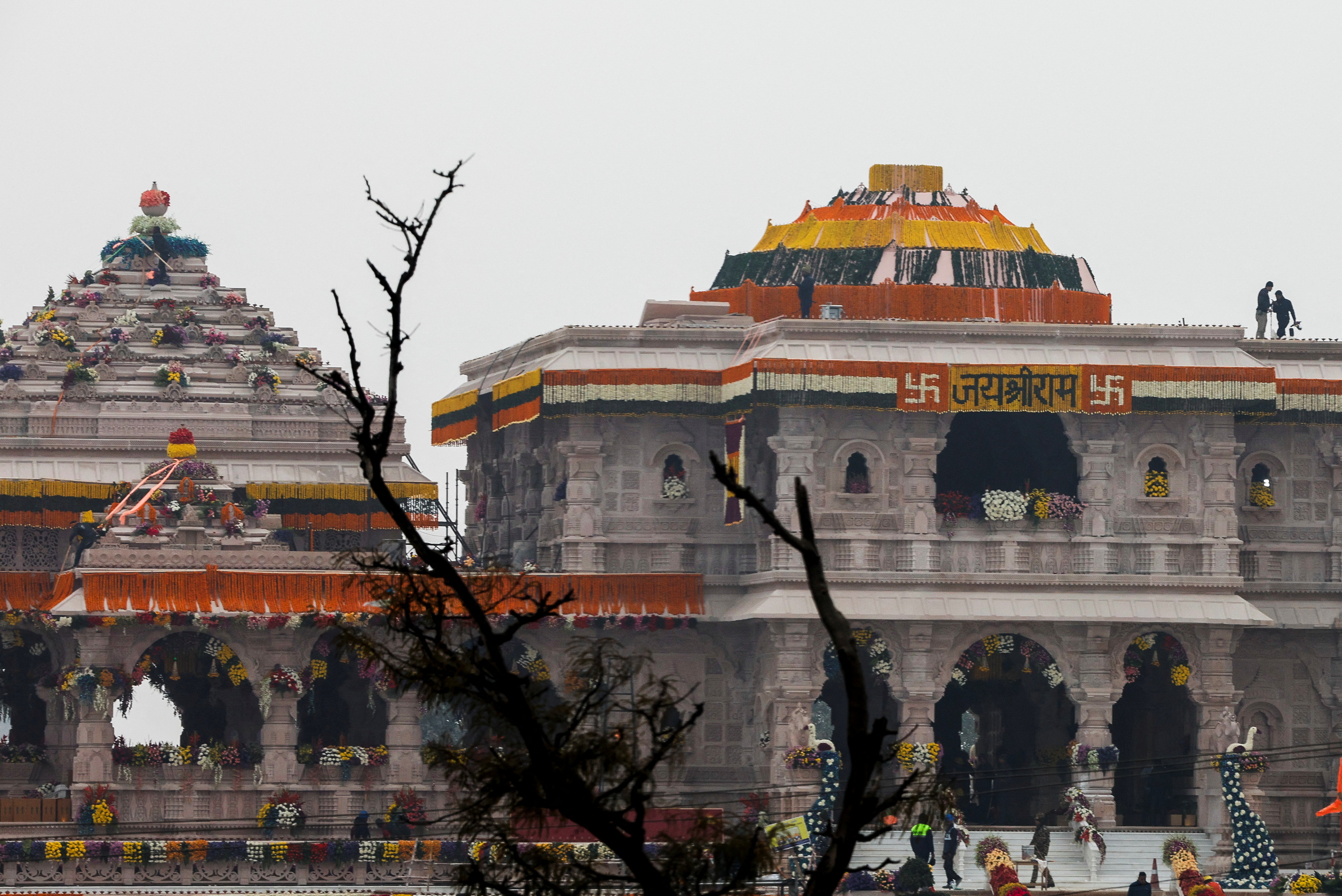 Police officers stand on top of the decorated temple of Hindu Lord Ram on the eve of its opening in Ayodhya, in India, January 21, 2024. REUTERS/Adnan Abidi