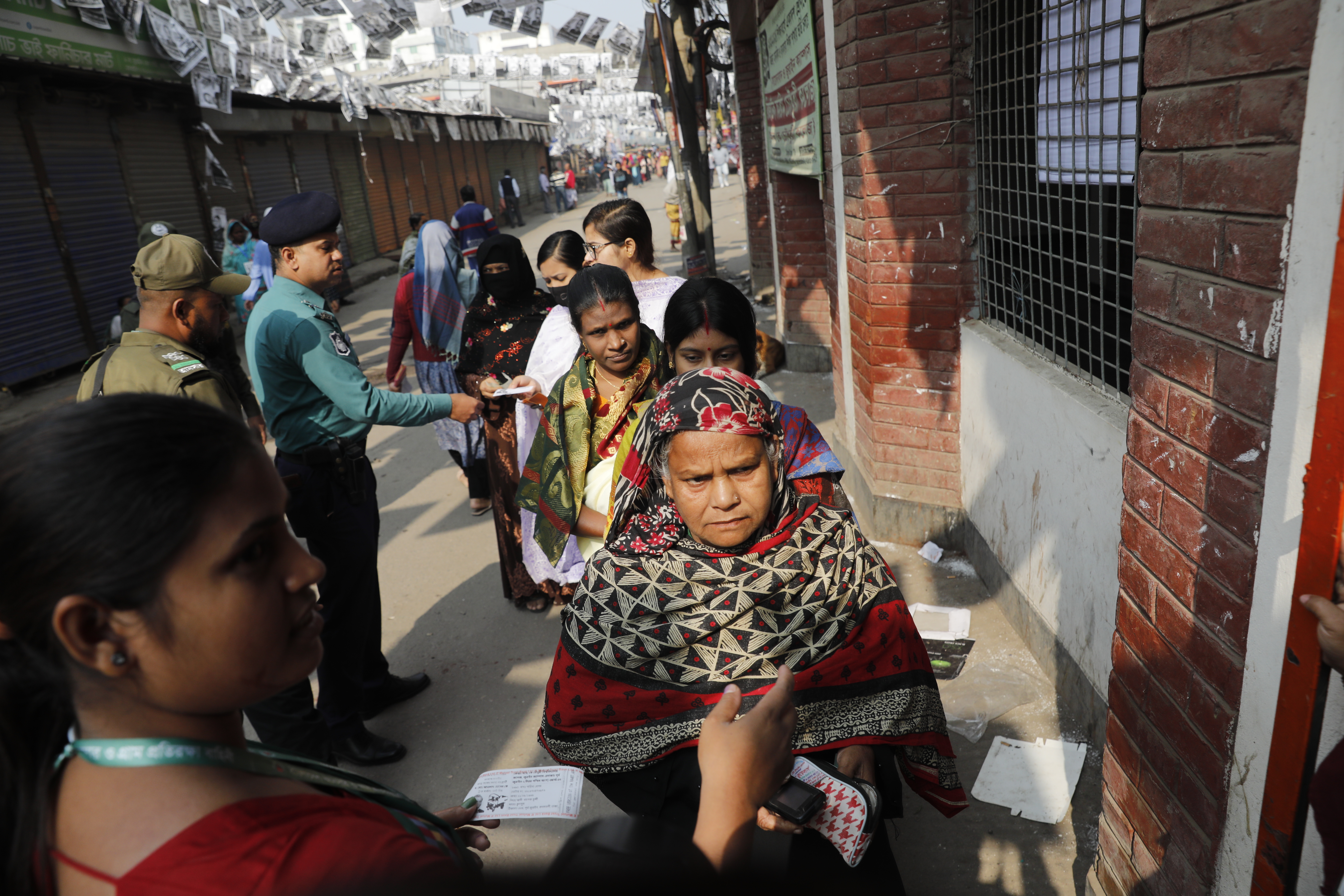 People wait outside polling station to cast their votes in Jurain, Dhaka.