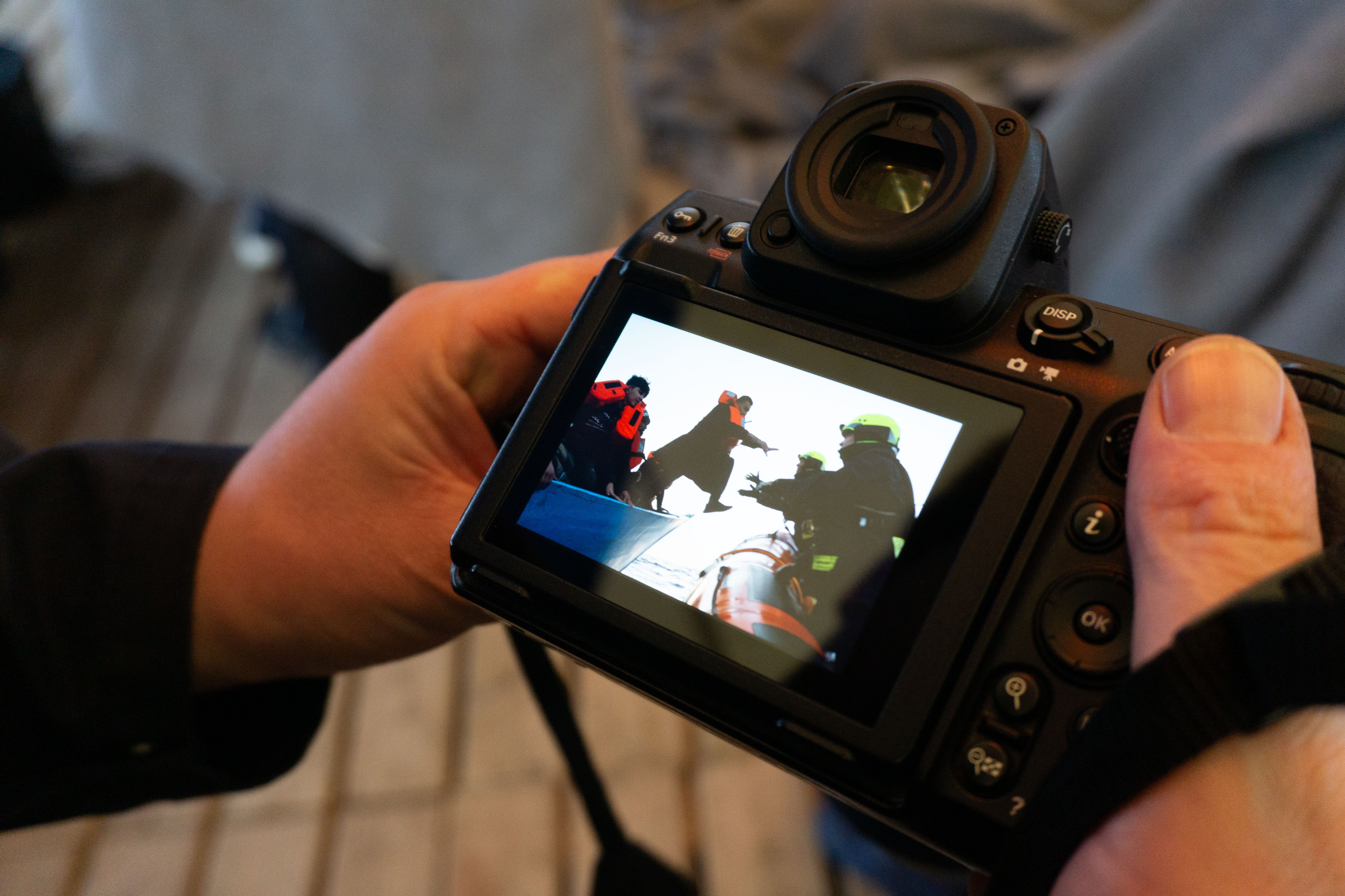 Photo of the camera viewer with a man leaping onto the RIB from the battered blue boat