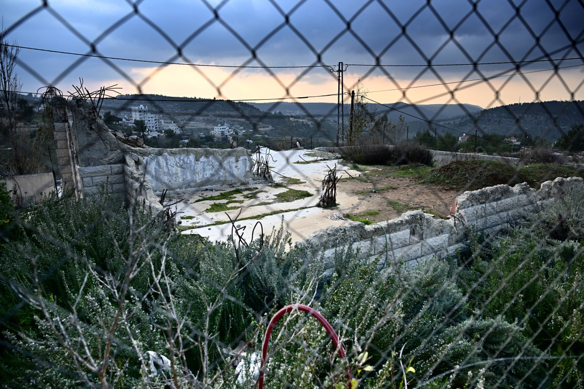 a bulldozed house behind a fence in Al-Walaja