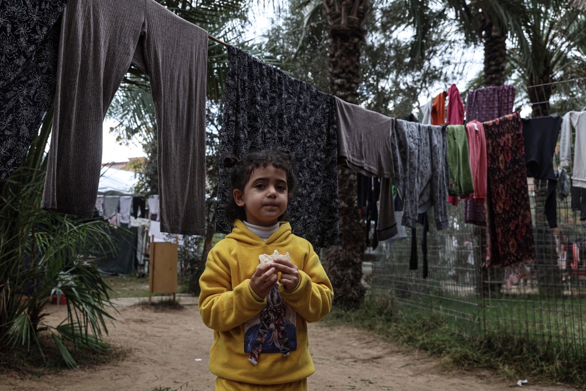 A displaced Palestinian eats a sandwich in the zoo in Rafah in the southern Gaza Strip, on January 2, 2024, where they sought refuge amid the ongoing conflict between Israel and the militant group Hamas.