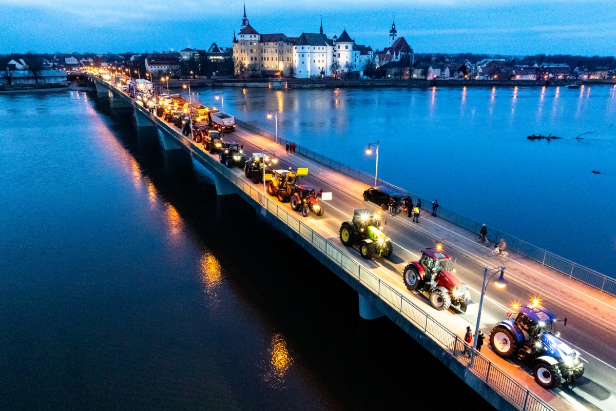 Picture taken with a drone shows farmers on their tractors driving past Hartenfels Castle in Torgau, eastern Germany,