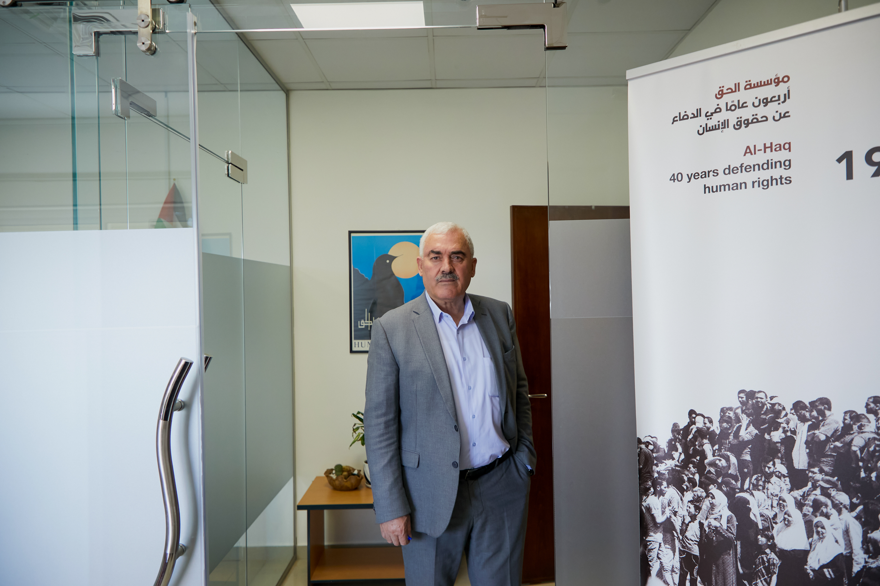 Shawan stands in office in grey suit