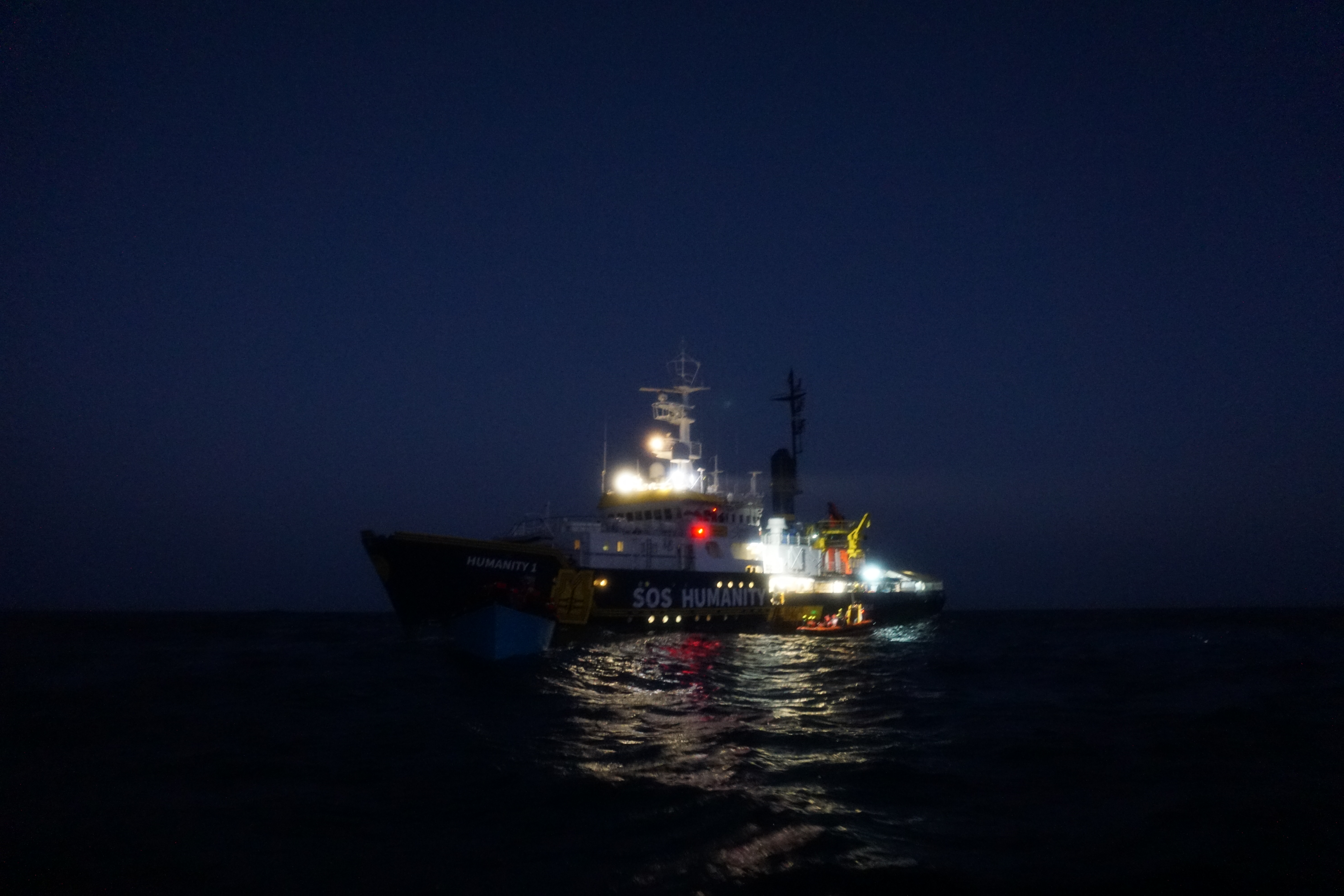 Humanity 1 in a dark sea, its lights on
