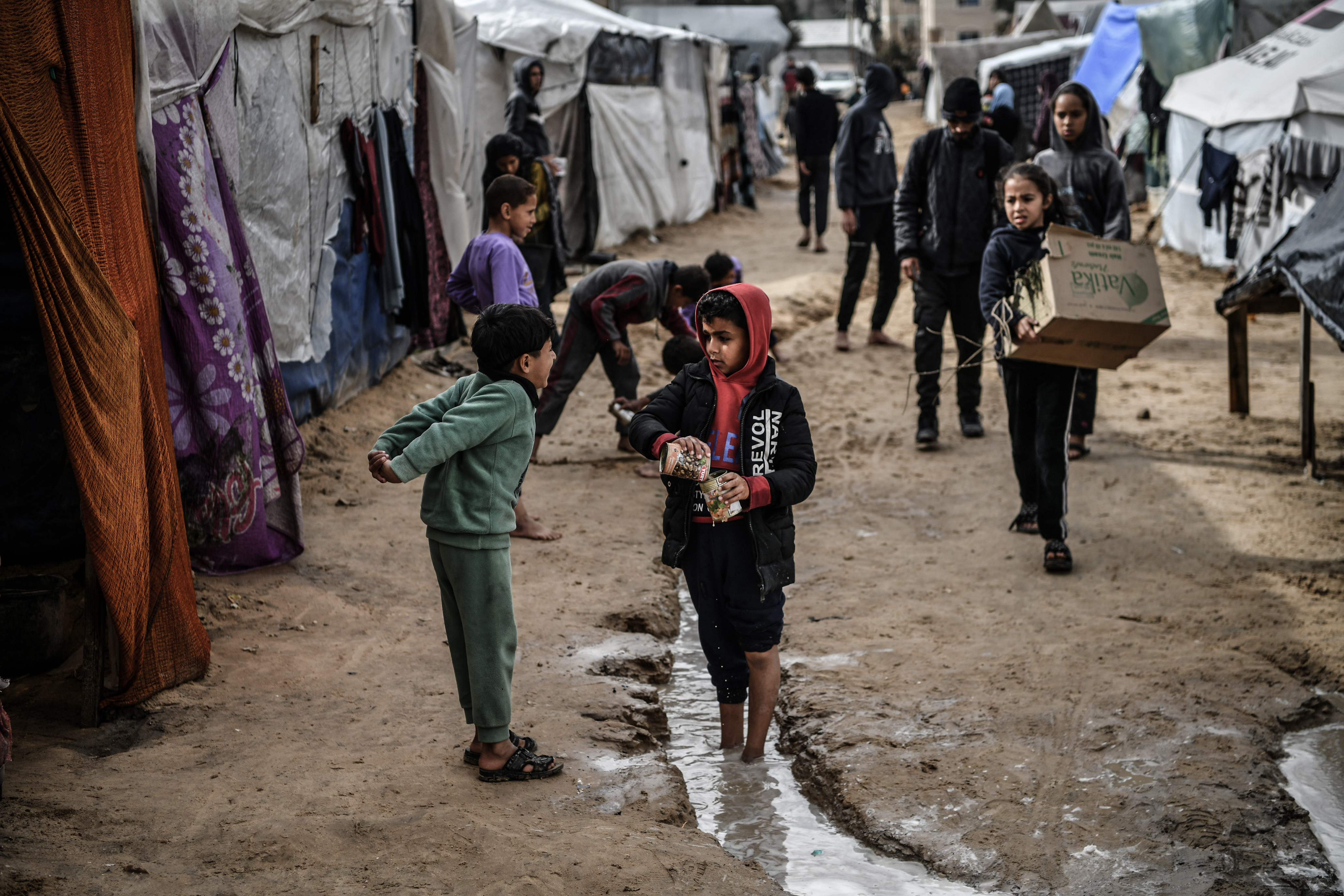 Children spend their time in front of makeshift tents during the cold weather as Palestinians, who left their homes, take shelter in the city of Rafah to protect themselves from Israeli bombardment