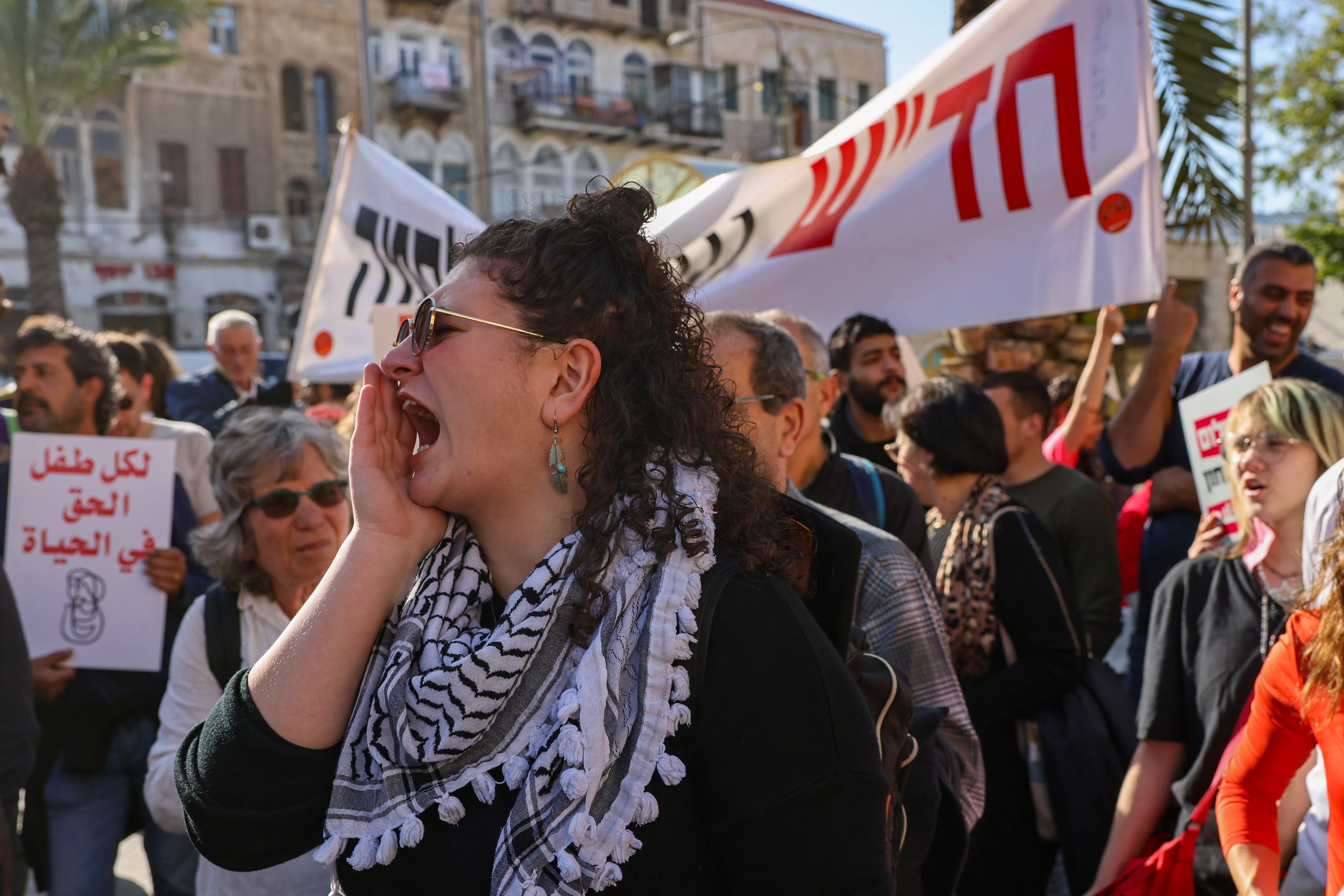 People hold placards and shout slogans as they take part in a protest calling for a ceasefire and for the release of Israeli hostages held in Gaza