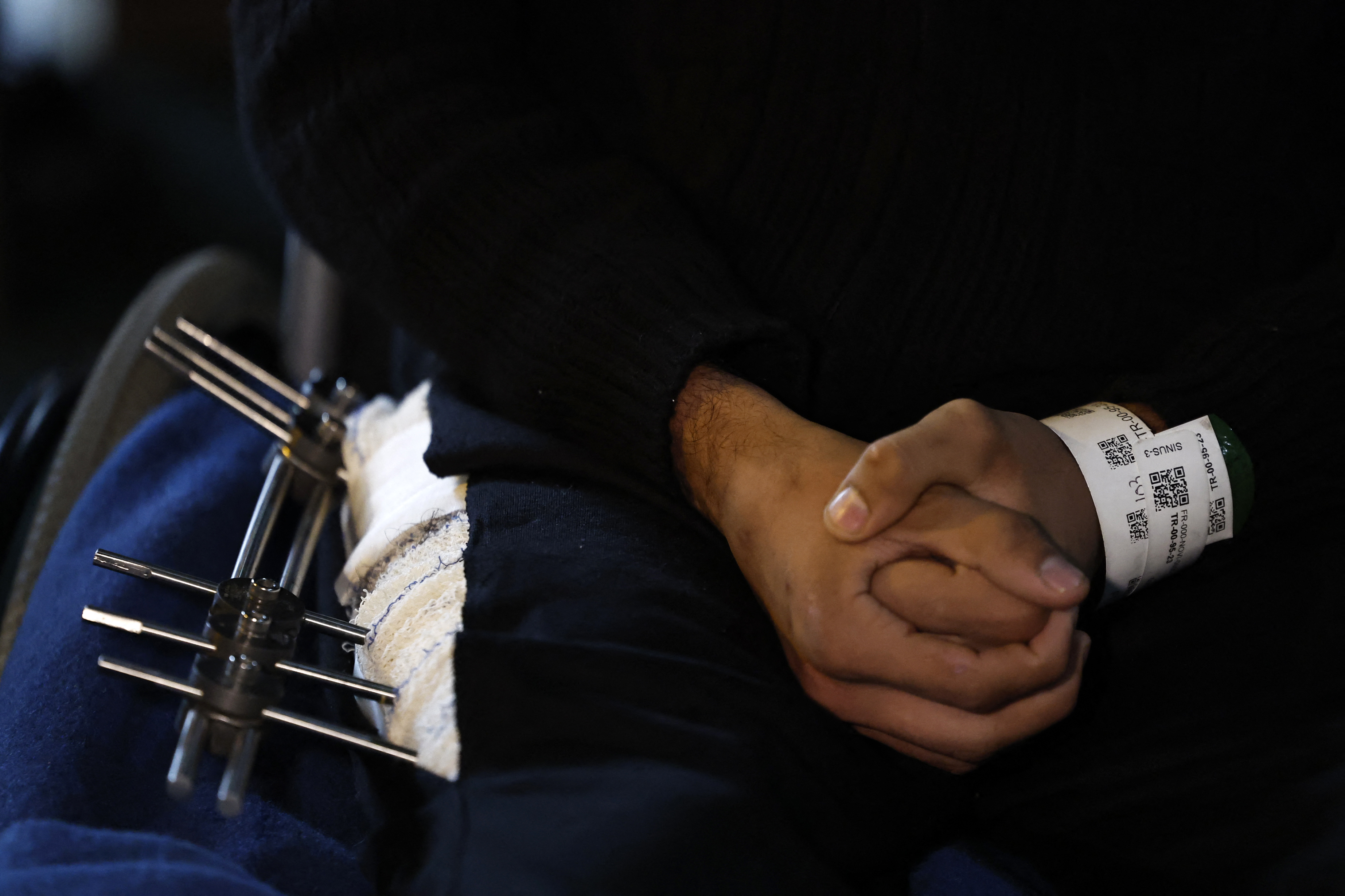A Palestinian youth, with a pin in his thigh, sits on a wheelchair onboard the French LHD Dixmude military ship, which serves as a hospital to treat wounded Palestinians, as it docks at the Egyptian port of Al-Arish on January 21