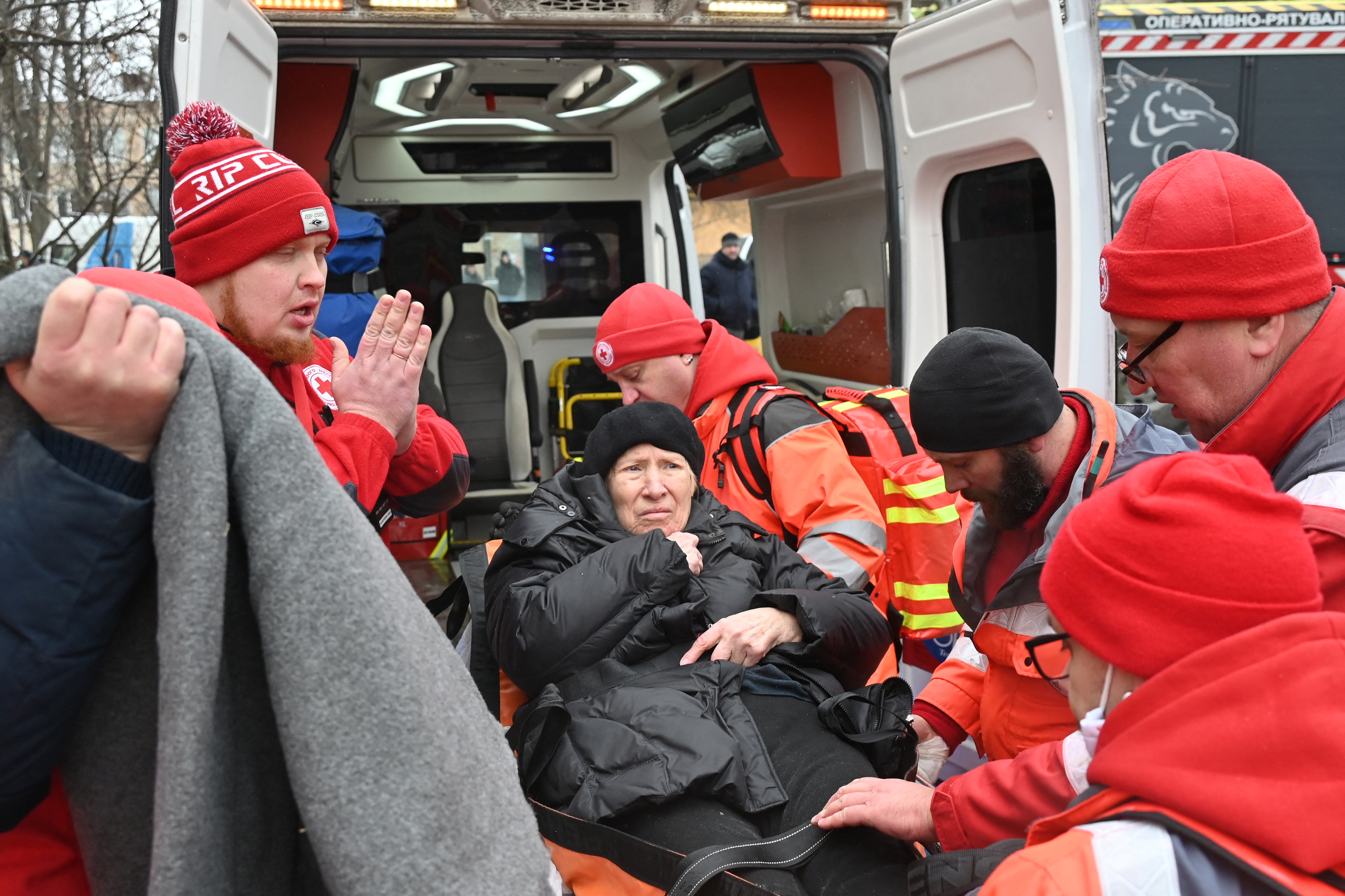 Rescuers lift a woman on a stretcher into an ambulance after Russian missile attack on Kharkiv.