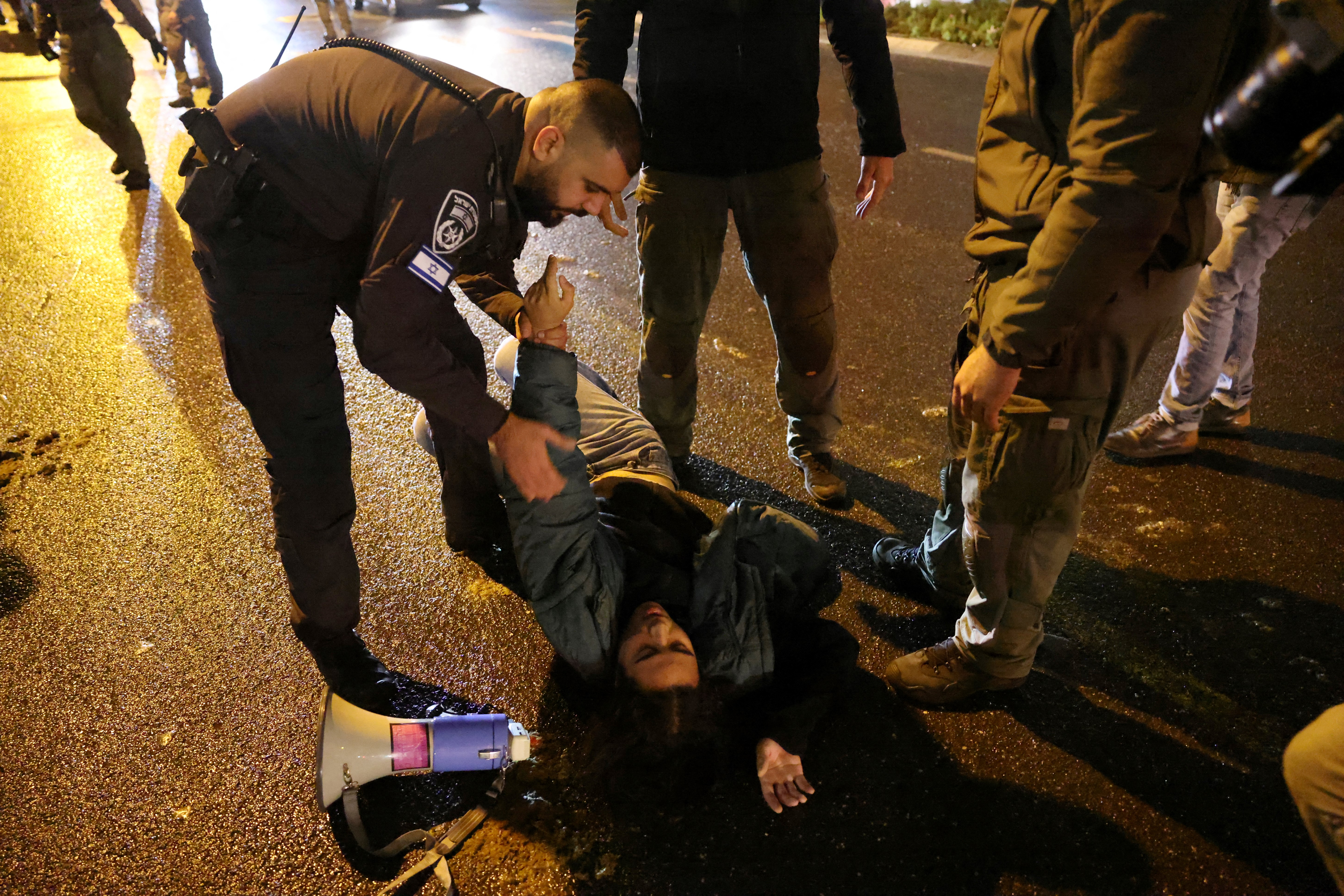 Israeli security forces disperse protesters on the sidelines of a rally calling for the government's resignation and early elections, amid Israel's ongoing war with the Palestinian Hamas militant group in Gaza, in Israel's central city of Tel Aviv on January 27