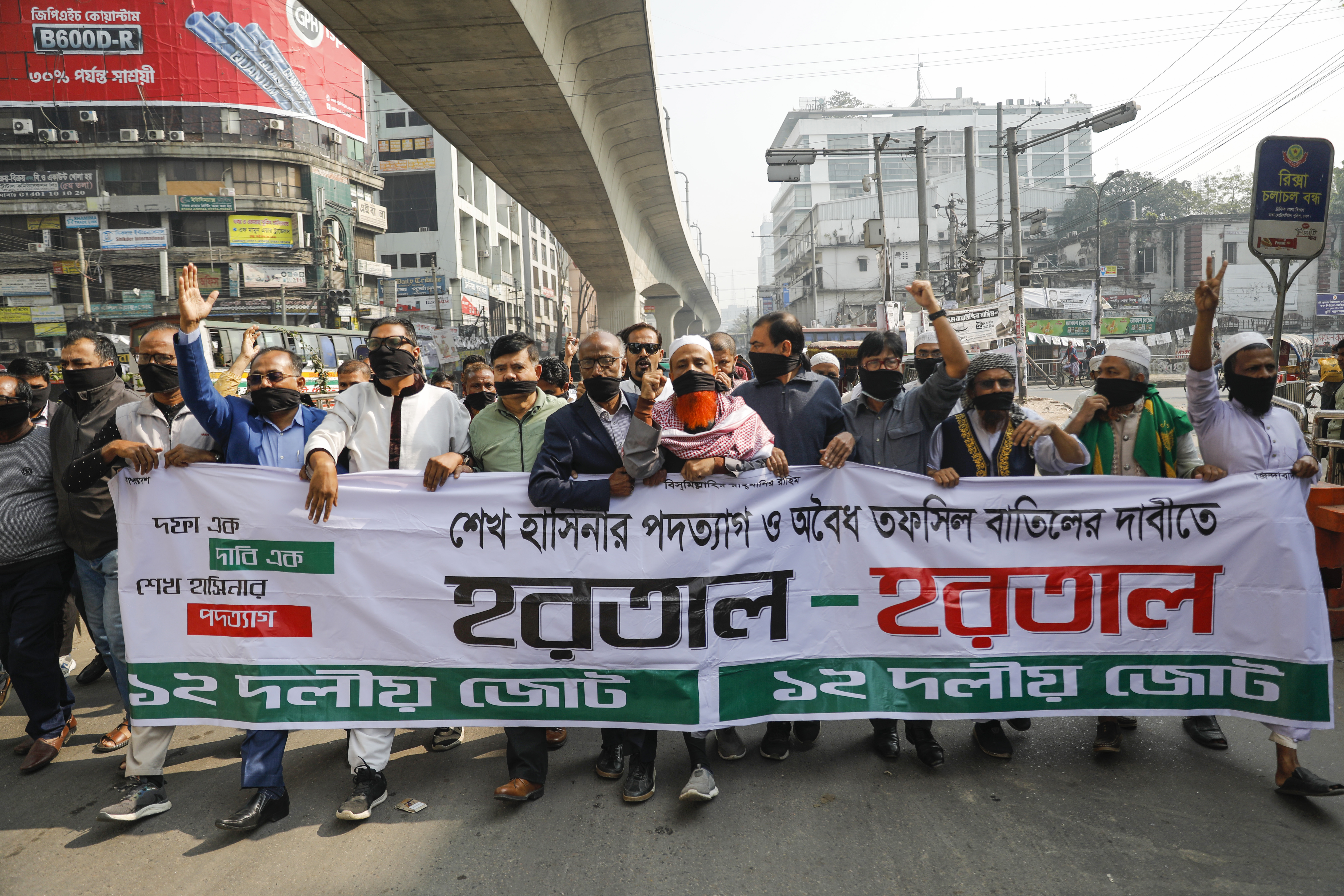 Activists of Bangladesh's opposition alliance march holding a banner with the words "Hartal" meaning strike