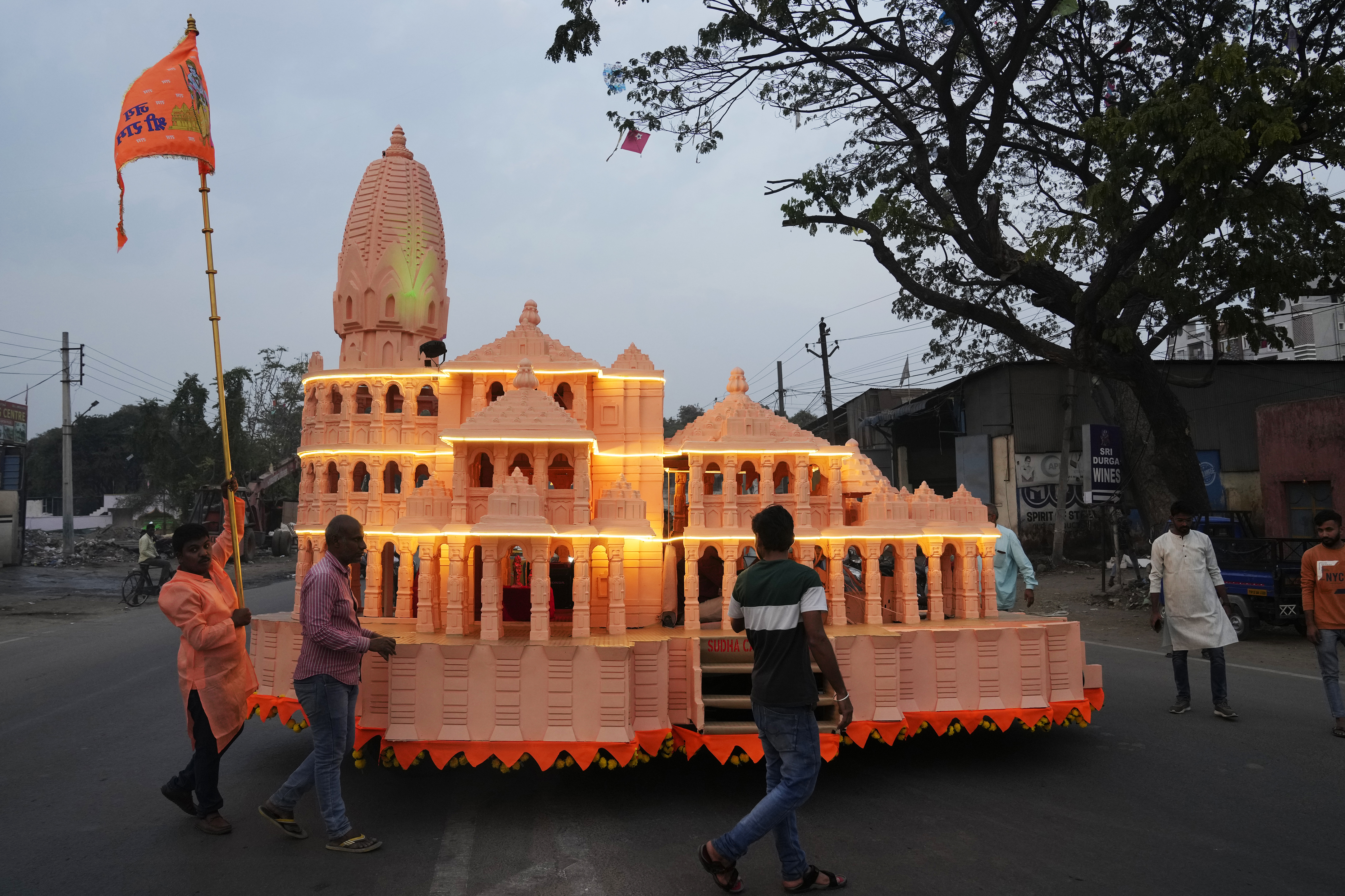 Devotees walk around a car built in the shape of the new Ram temple in Ayodhya