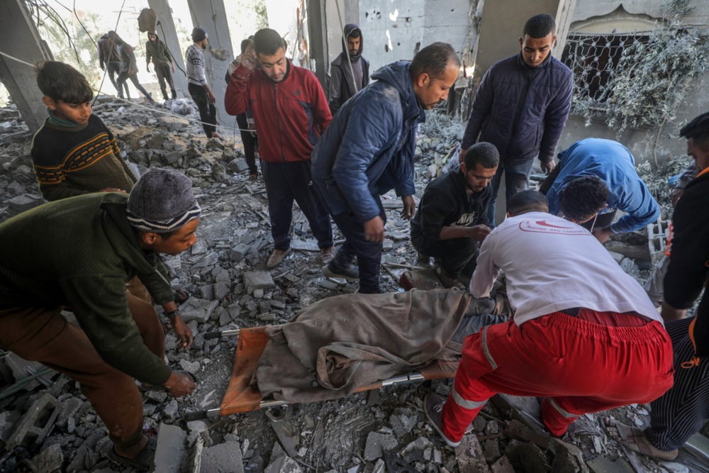 epa11171825 Palestinians recover a body from the rubble of a destroyed house following Israeli air strikes, in Deir Al Balah, central Gaza Strip, 22 February 2024. More than 29,300 Palestinians and over 1,300 Israelis have been killed, according to the Palestinian Health Ministry and the Israel Defense Forces (IDF), since Hamas militants launched an attack against Israel from the Gaza Strip on 07 October 2023, and the Israeli operations in Gaza and the West Bank which followed it. EPA-EFE/MOHAMMED SABER