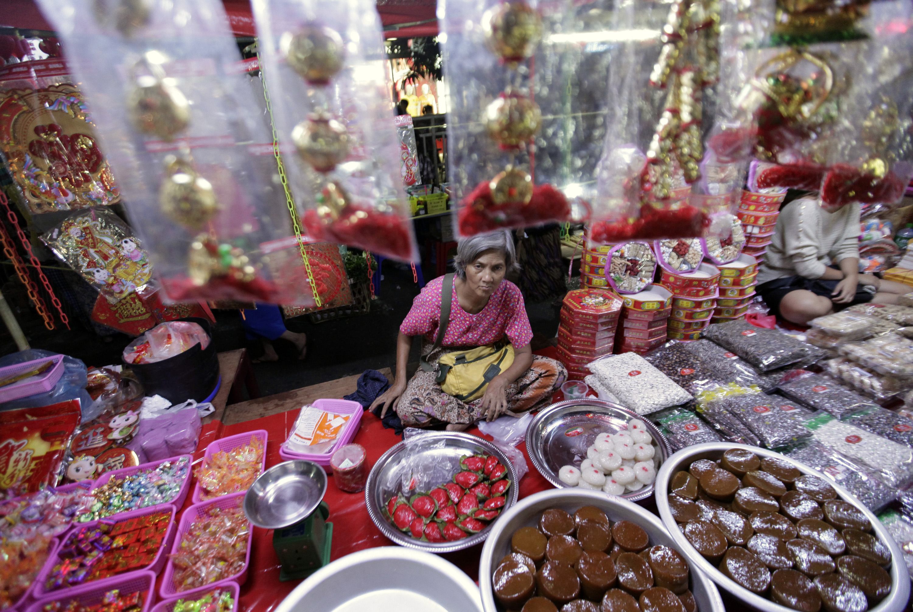 A woman sells Chinese traditional snacks and gifts ahead of Chinese Lunar New Year at Chinatown in Yangon February 7, 2013.
