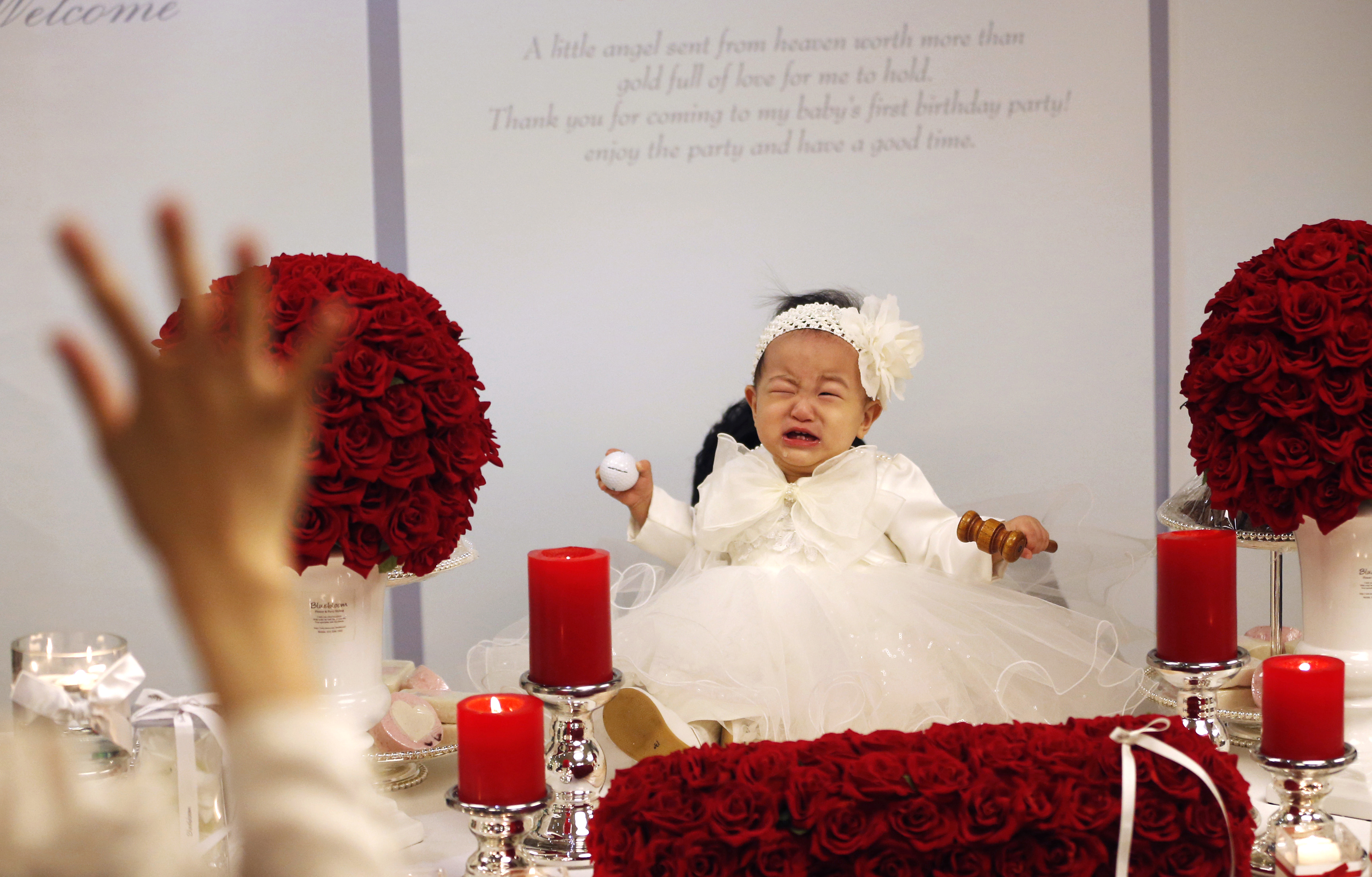South korean baby in white dress cries at birthday celebration