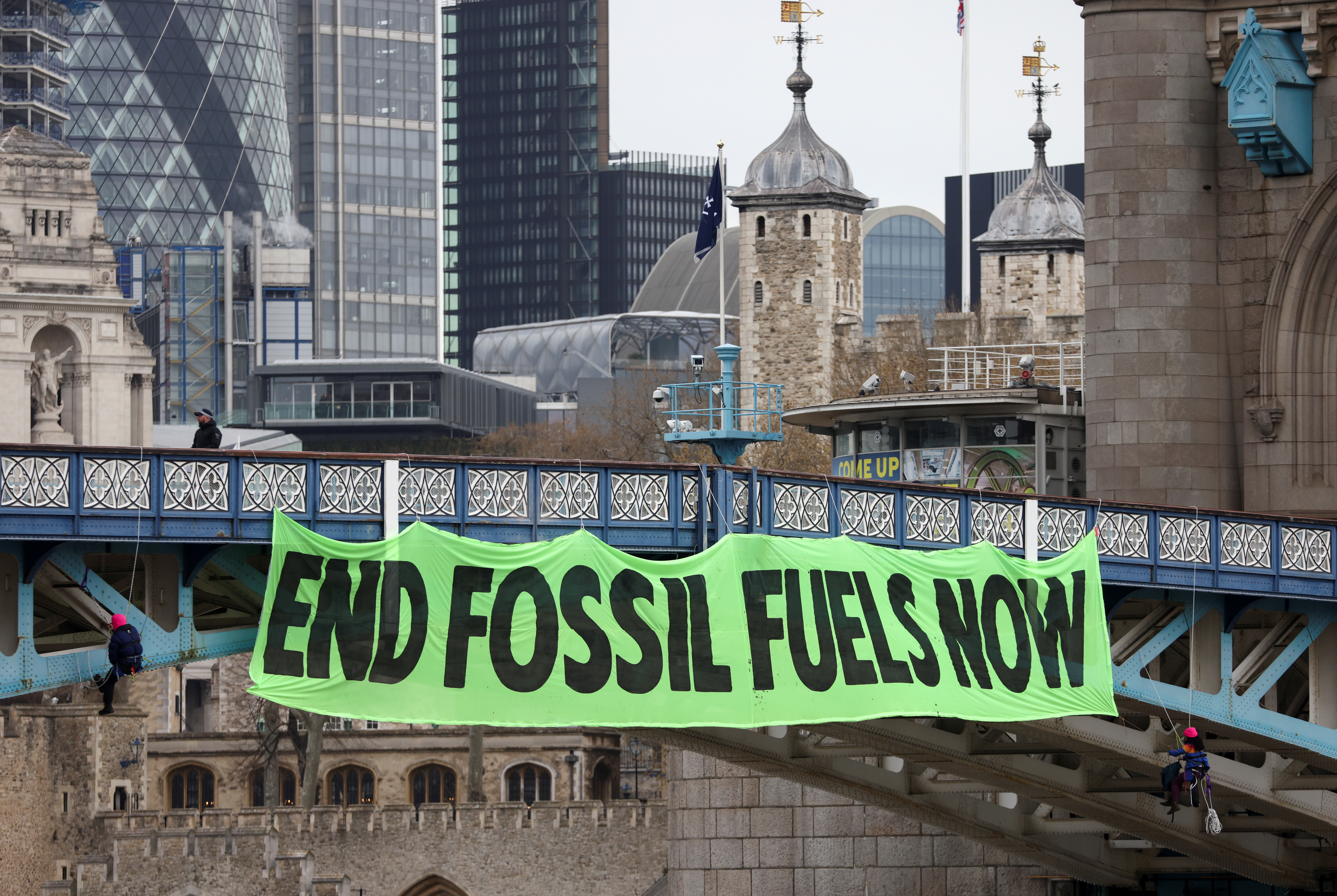 Climate change activists hang a sign on Tower Bridge during a demonstration