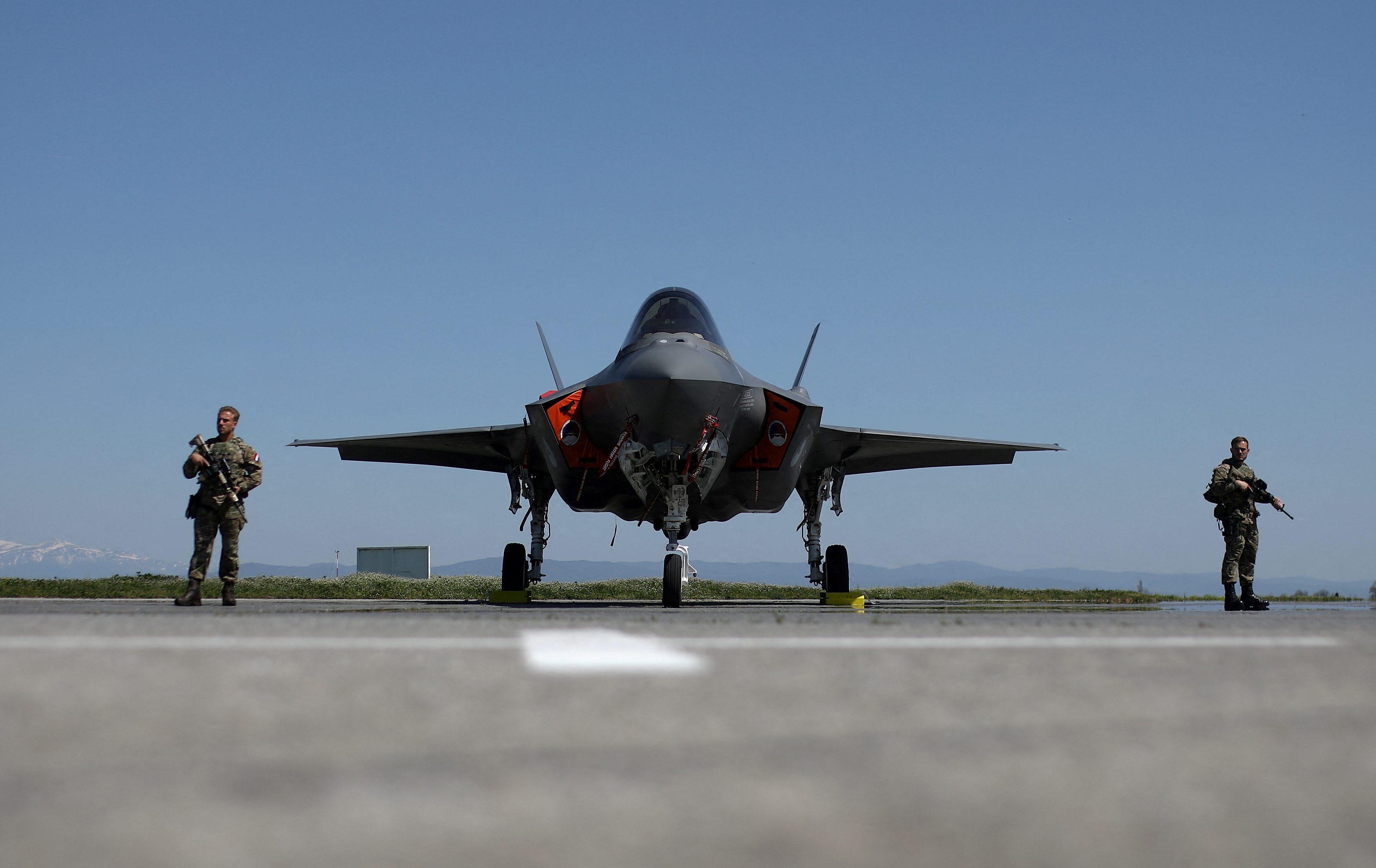 Dutch soldiers stand guard near a Royal Netherlands Air Force F-35 at Graf Ignatievo airbase, Bulgaria, April 14, 2022. REUTERS/Stoyan Nenov TPX IMAGES OF THE DAY