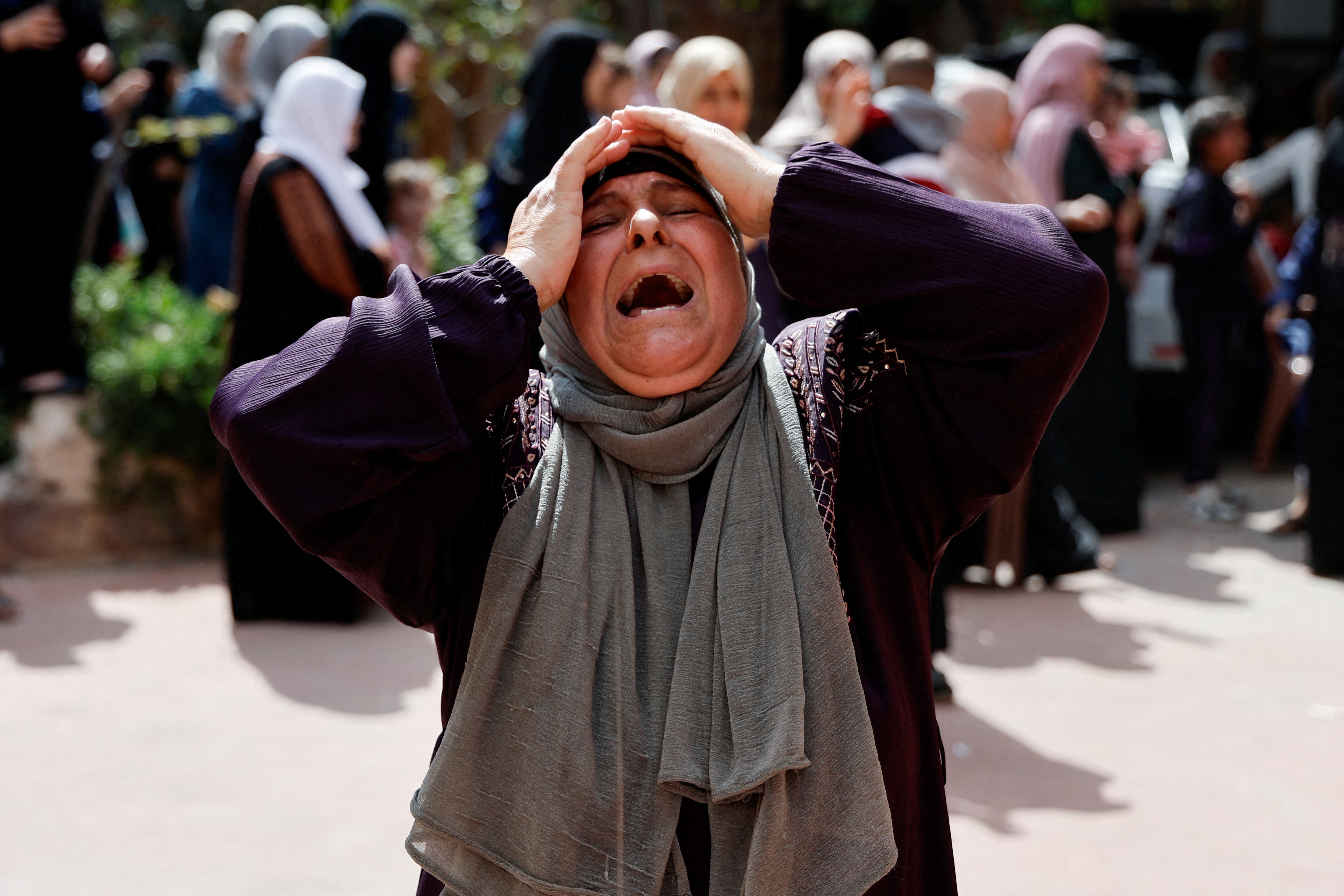A woman reacts as mourners attend the funeral of four Palestinians killed in clashes with Israeli settlers,