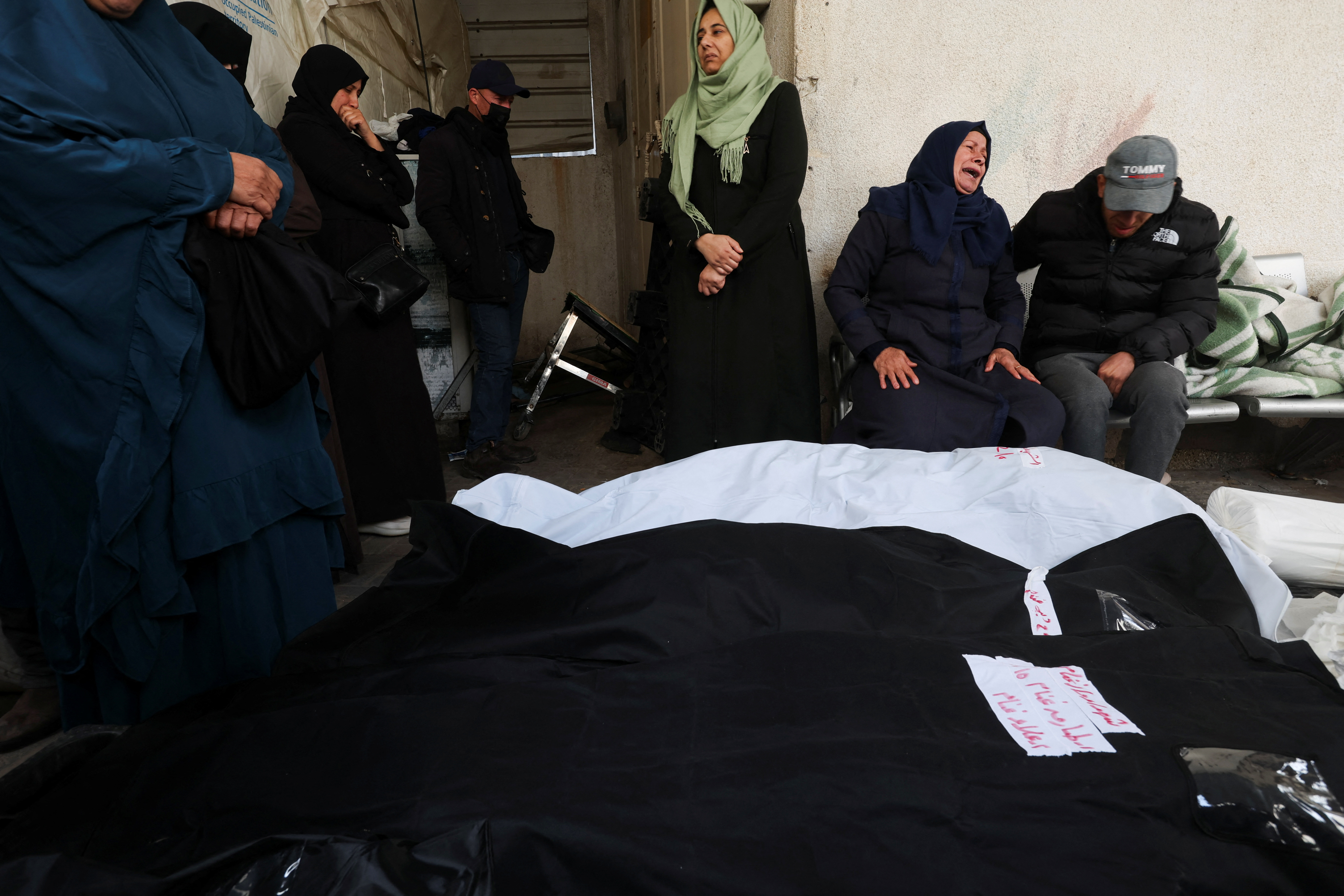 Mourners react next to dead bodies