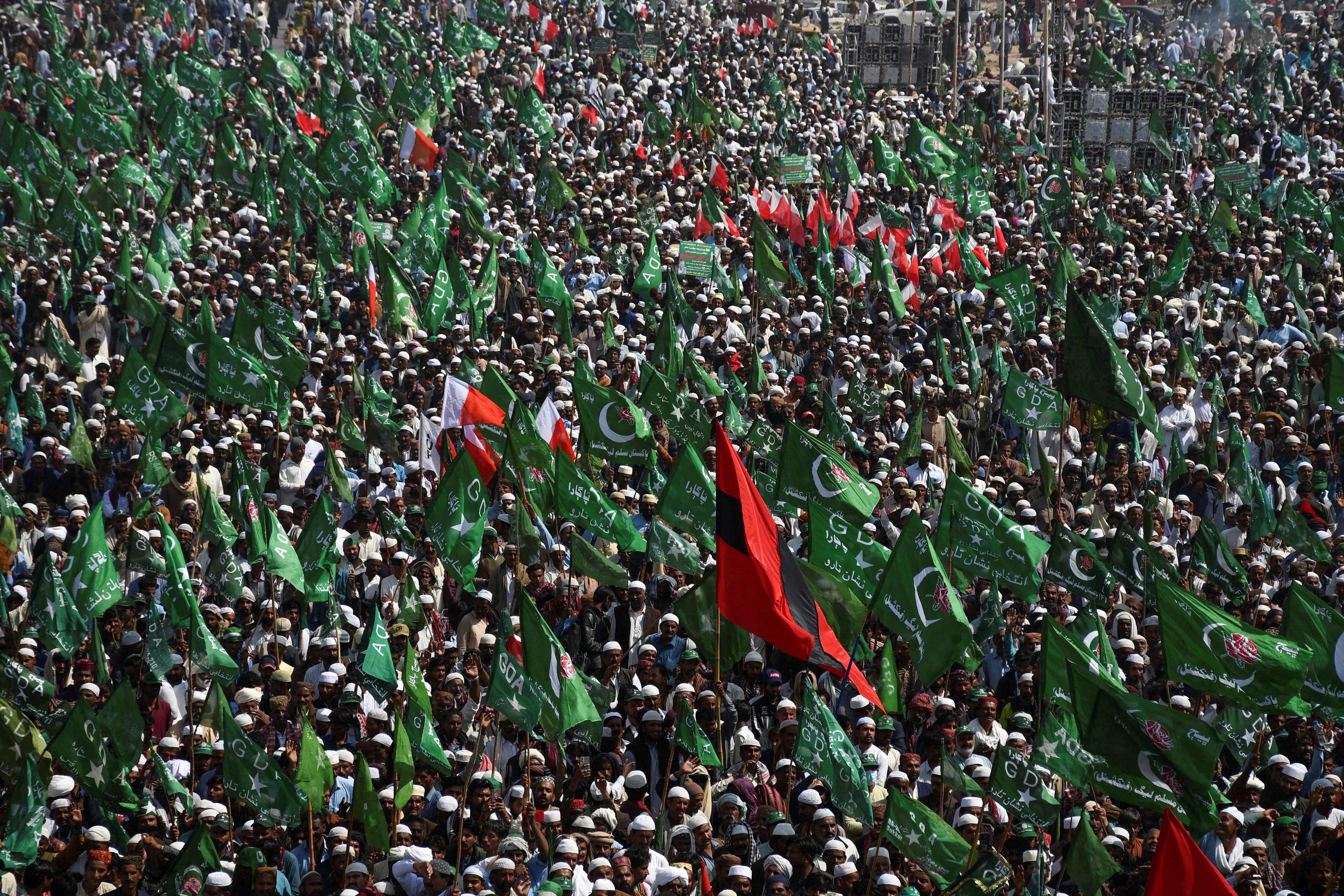 Supporters of the Grand Democratic Alliance (GDA), an alliance of political parties, carry flags as they gather for a sit-in protest against, what they call election rigging and are demanding free and fair results of the general elections along the main Highway in Jamshoro, Pakistan February 16