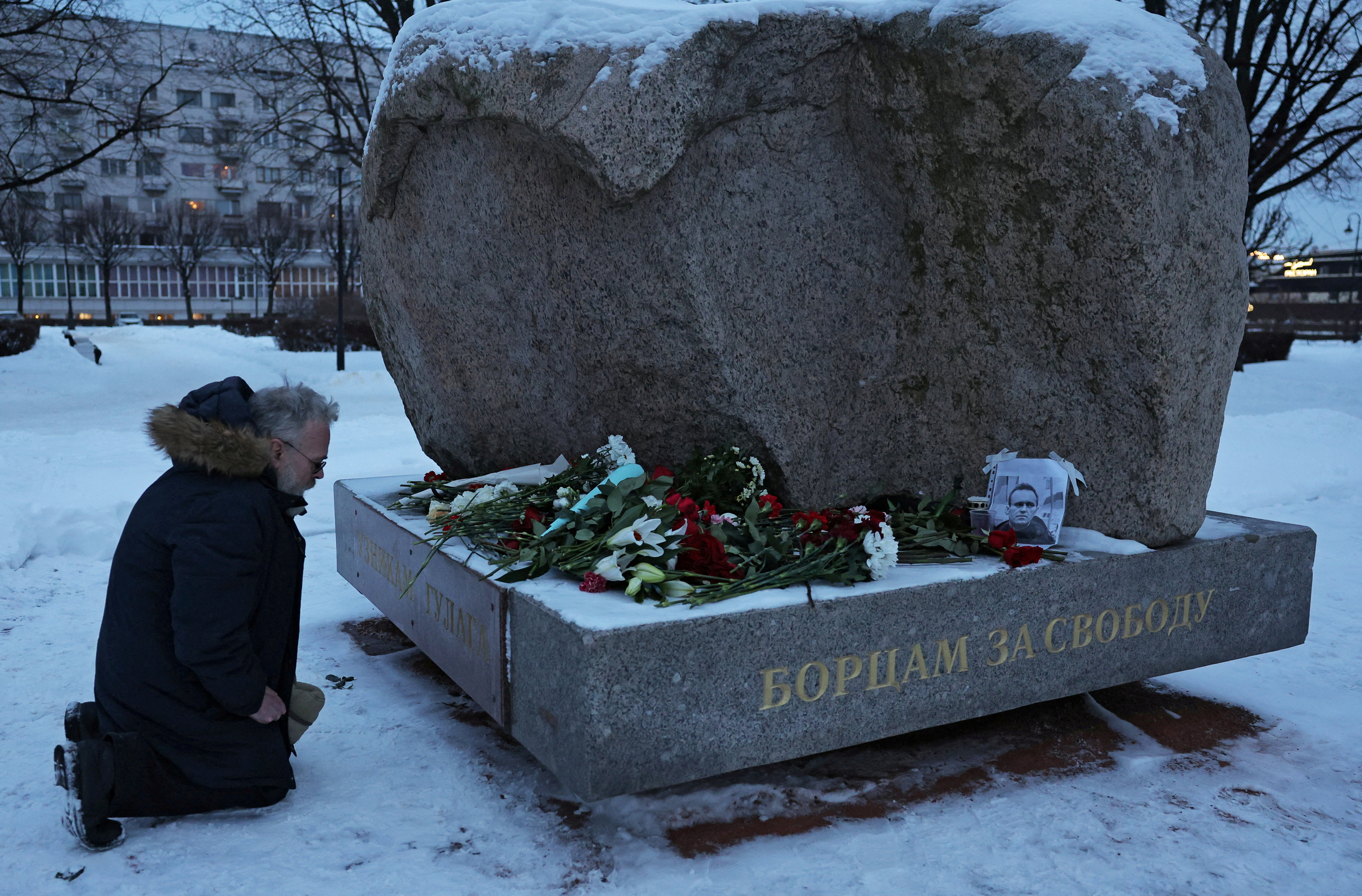 A man kneels at the monument to the victims of political repressions, where people lay flowers following the death of Russian opposition leader Alexei Navalny, in Saint Petersburg, Russia February 16, 2024. REUTERS/Stringer TPX IMAGES OF THE DAY