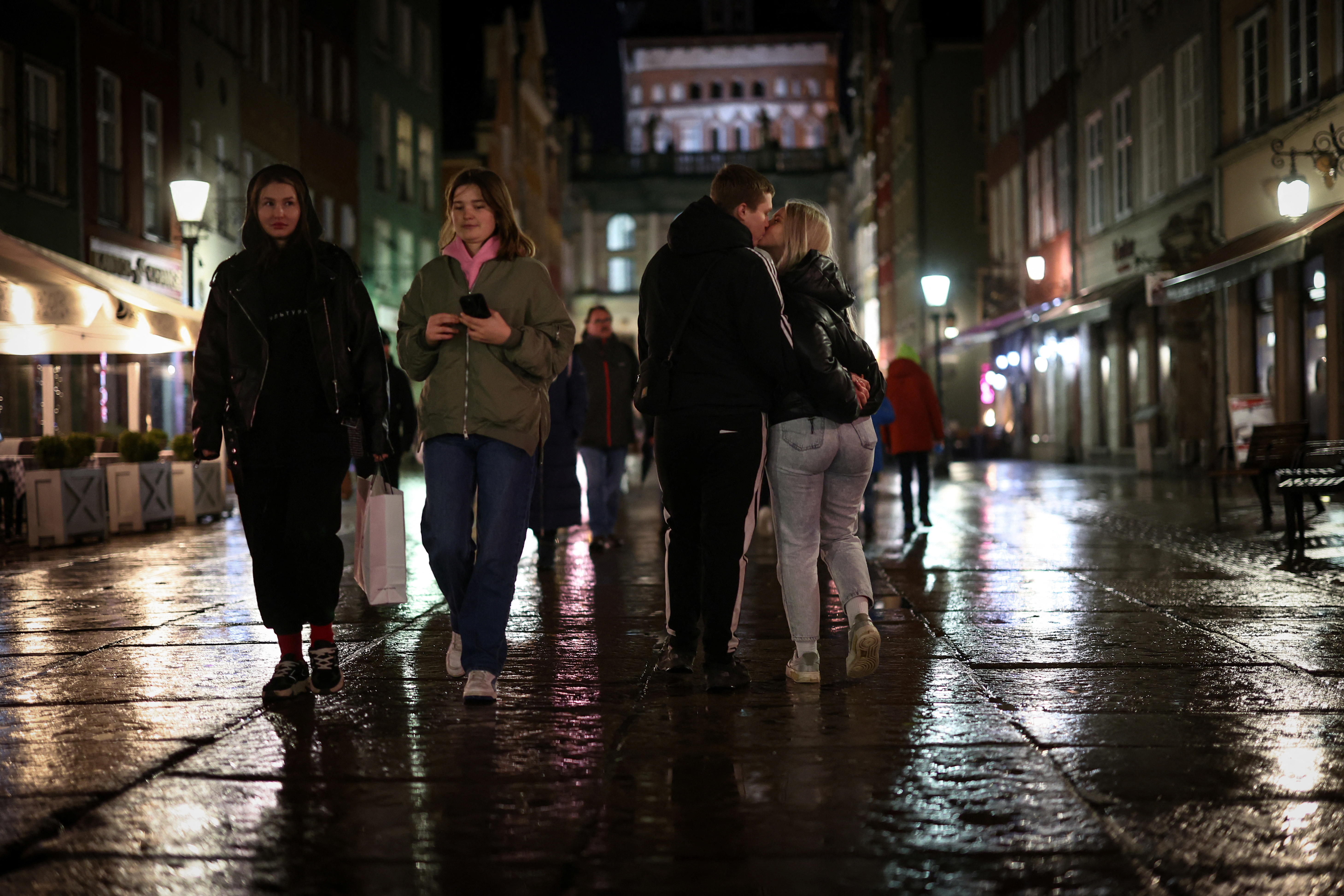 Dariia Vynohradova, 17, from Kharkiv, kisses her boyfriend Dmytro Demchevskyi, 18, from Yuzhnoukrainsk, during an evening walk in the Old Town in Gdansk, Poland, February 21
