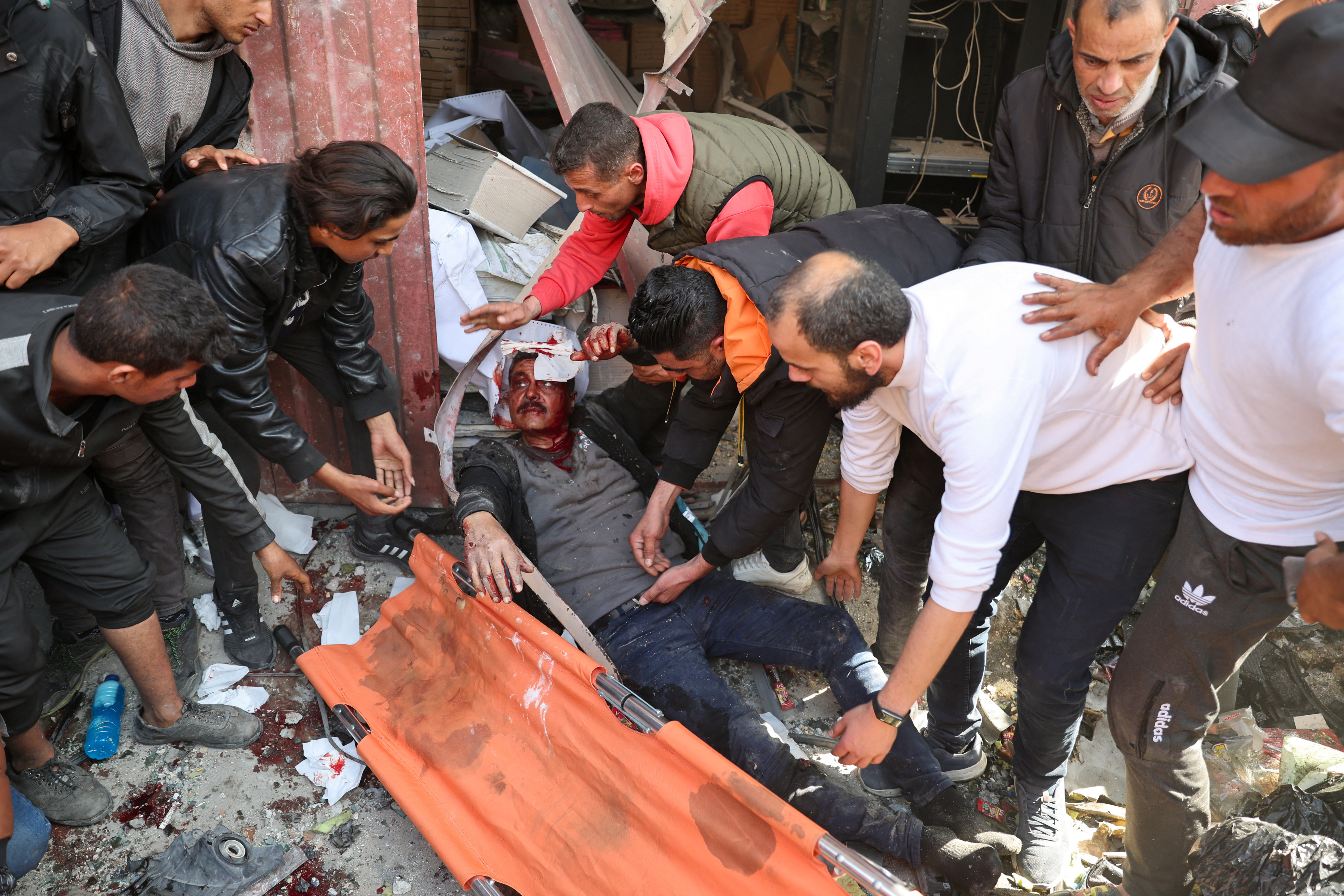 SENSITIVE MATERIAL. THIS IMAGE MAY OFFEND OR DISTURB Palestinians attend to a casualty, at the site of an Israeli strike on a house, amid the ongoing conflict between Israel and Hamas, in Rafah, in the southern Gaza Strip February 24, 2024. REUTERS/Ibraheem Abu Mustafa