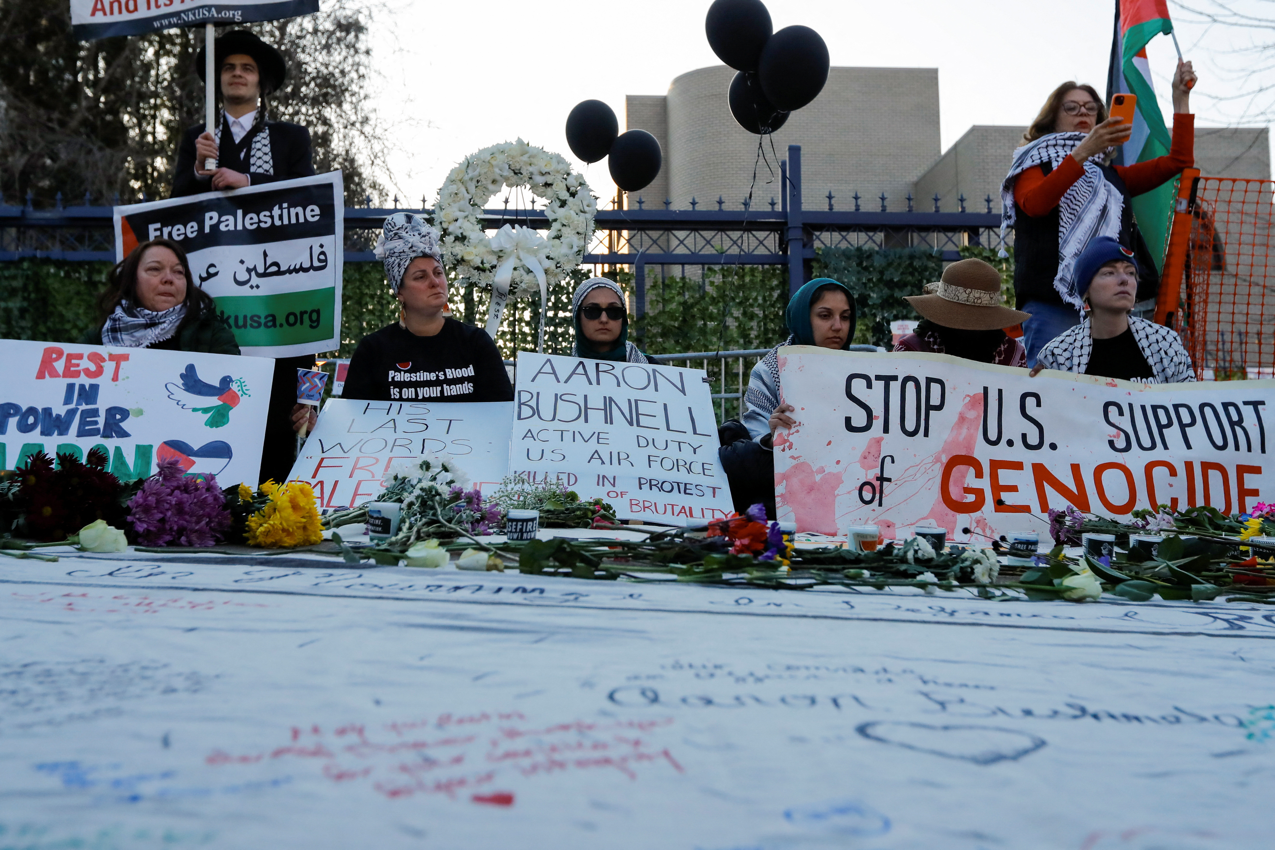 People participate in a memorial during a vigil for US Airman Aaron Bushnell, who died after setting himself on fire in front of the Israeli Embassy in Washington on February 25 in an apparent act of protest against the war in Gaza between Israel and Hamas, in Washington, D.C., US, February 26, 2024
