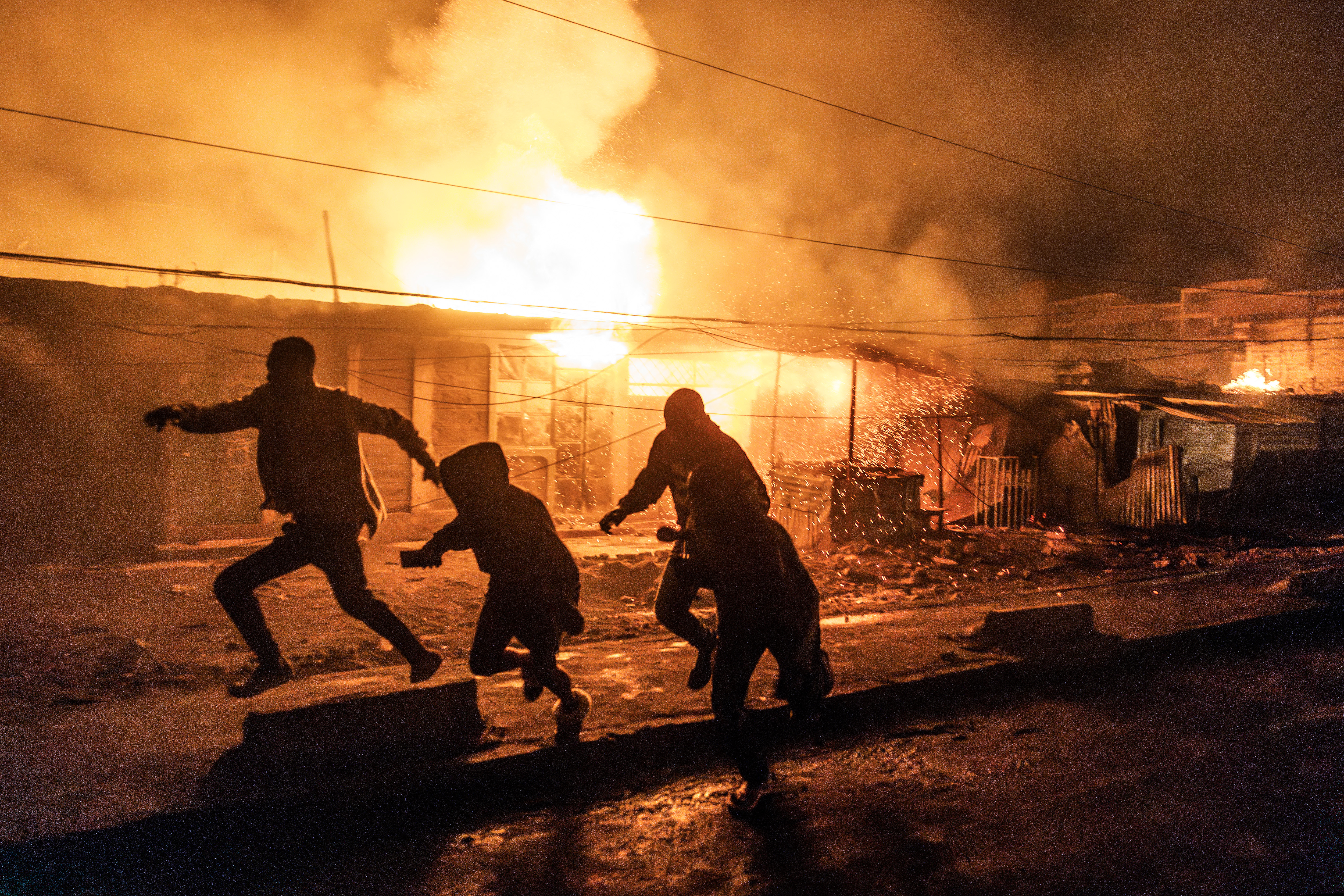People run for cover following a series of explosions in the Embakasi area of Nairobi on February 2