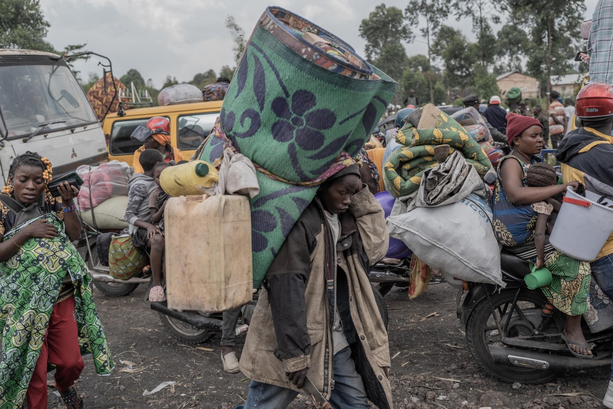 People carry some of their belongings as they flee the Masisi territory