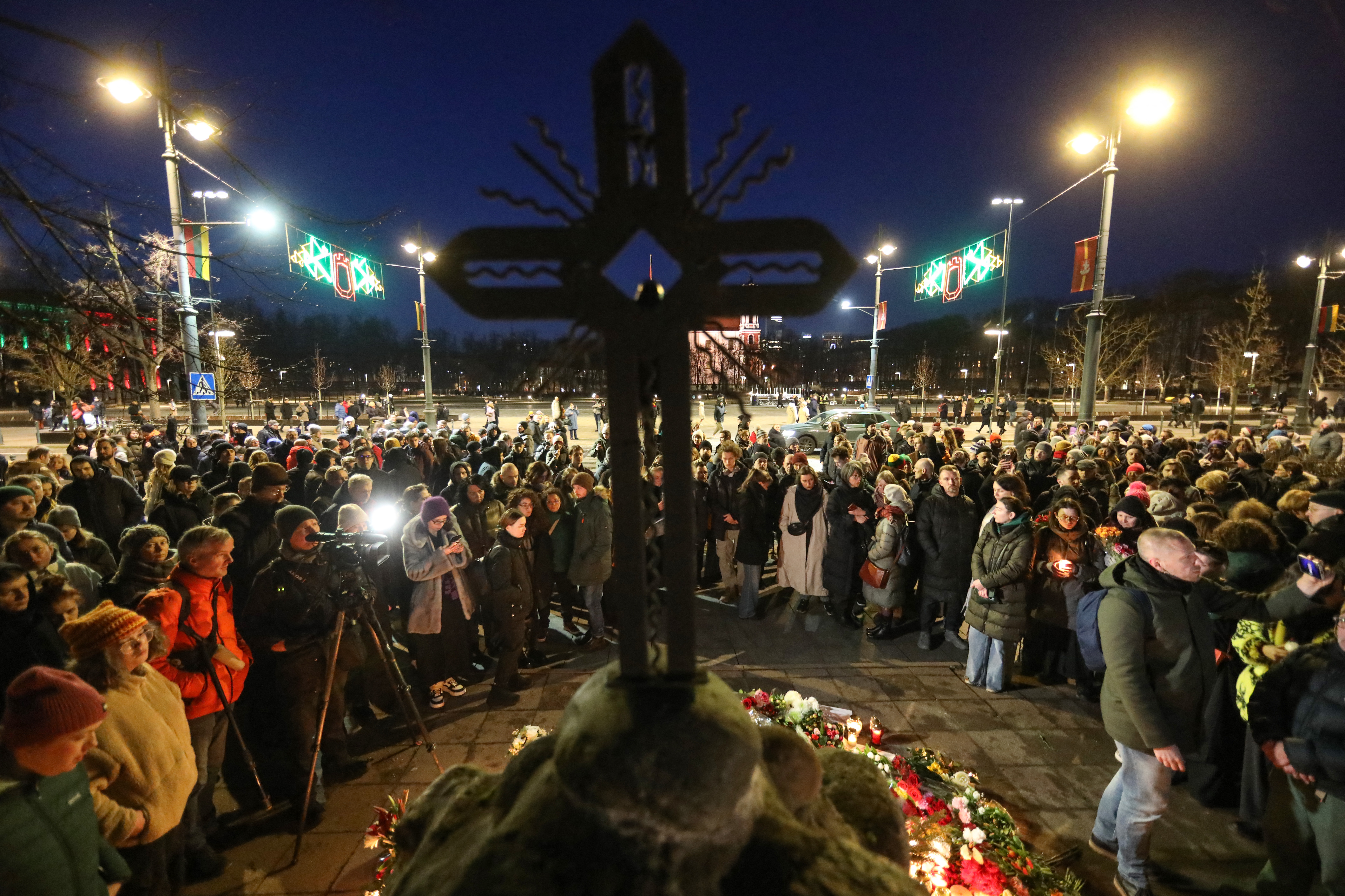 People demonstrate and pay their respect for late Russian opposition leader Alexei Navalny, at the monument for victims of political repressions in Vilnius, Lithuania, on February 16