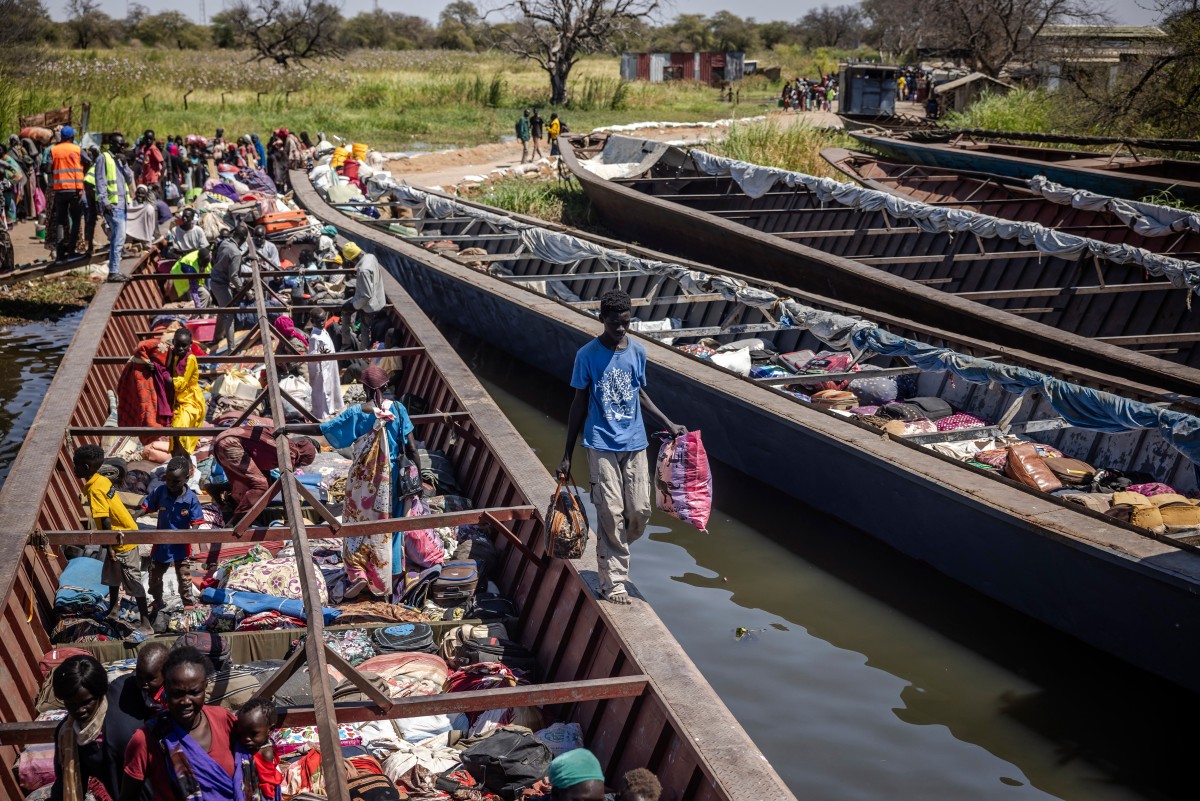 Sudanese refugees and ethnic South Sudanese who have fled the war in Sudan carry their
