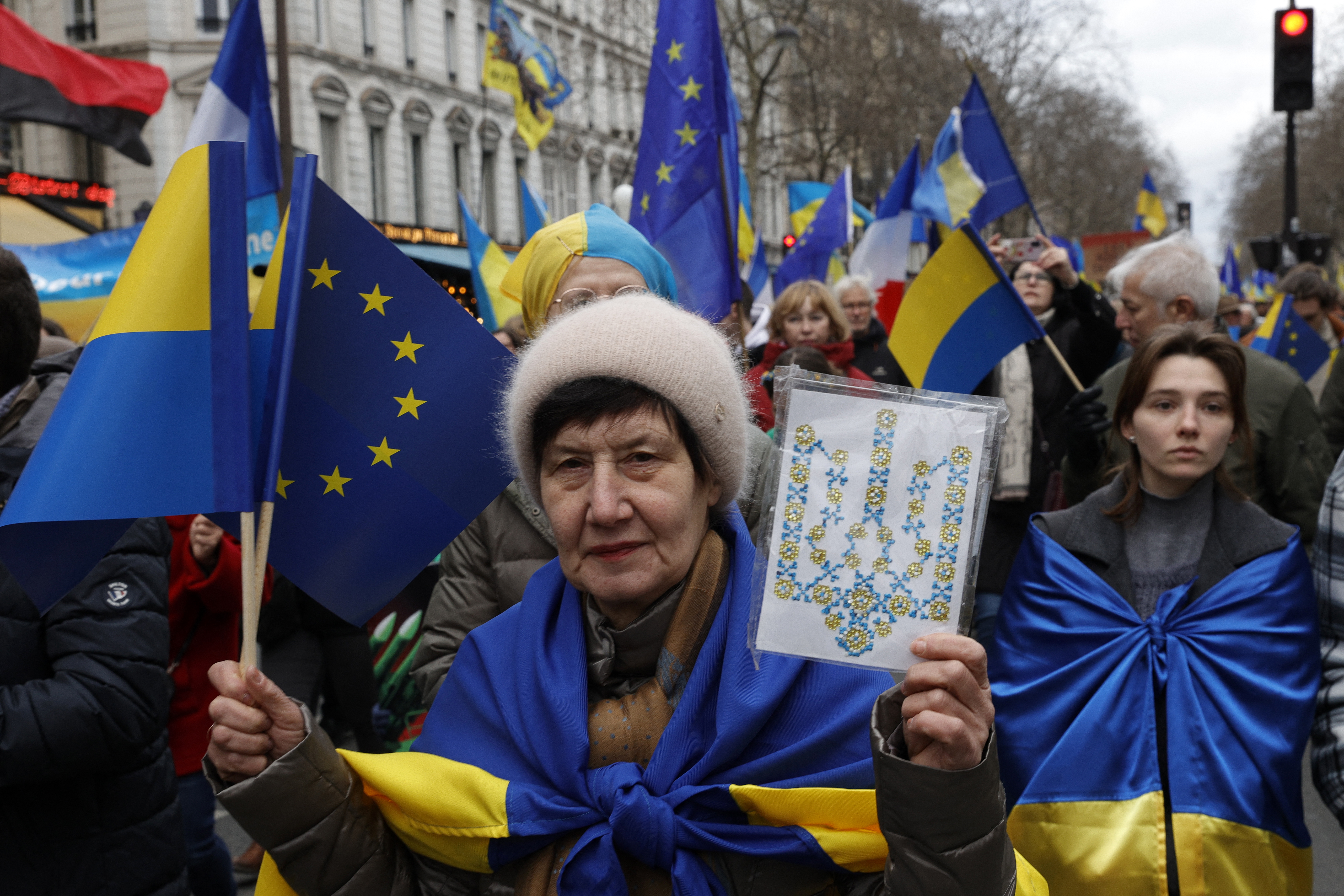 A participant holds the coat of arms of Ukraine during a rally for Ukraine on the second anniversary of Russia's invasion, at Place de la Republique in Paris on February 24