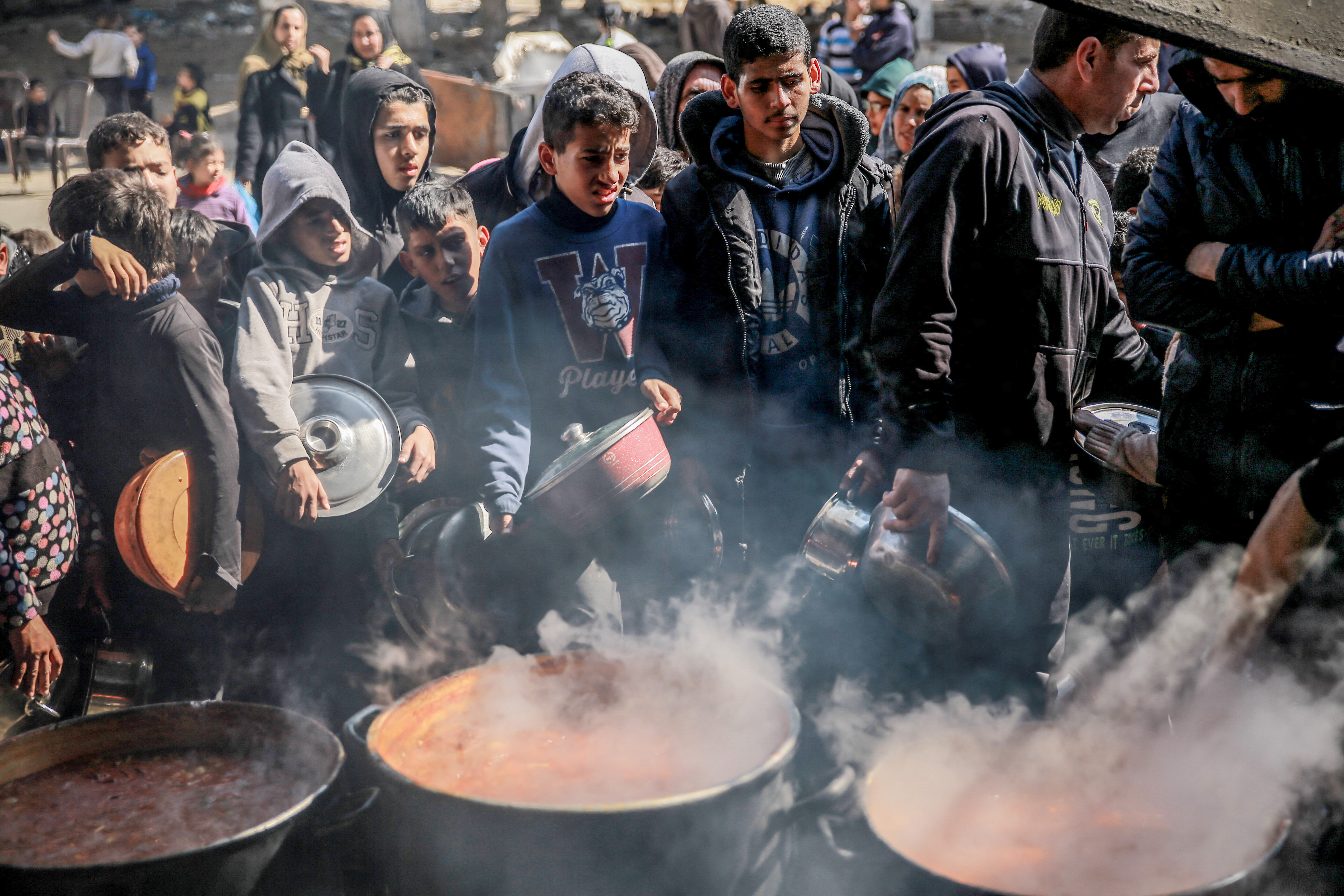Palestinians gather to collect aid food in Beit Lahia, in the northern Gaza Strip