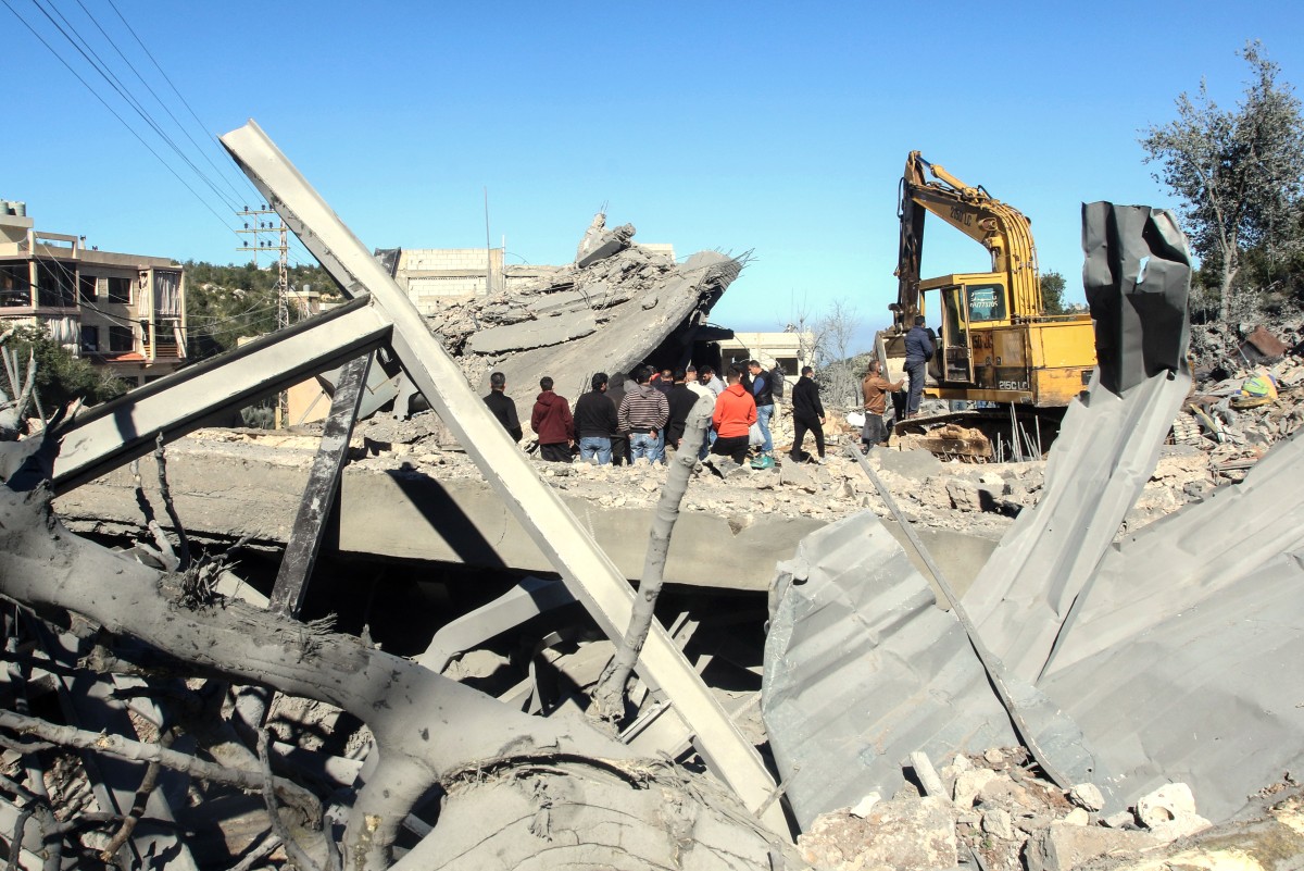 Residents and rescuers check the destruction after an overnight Israeli bombardment in the southern Lebanese village of Kafra