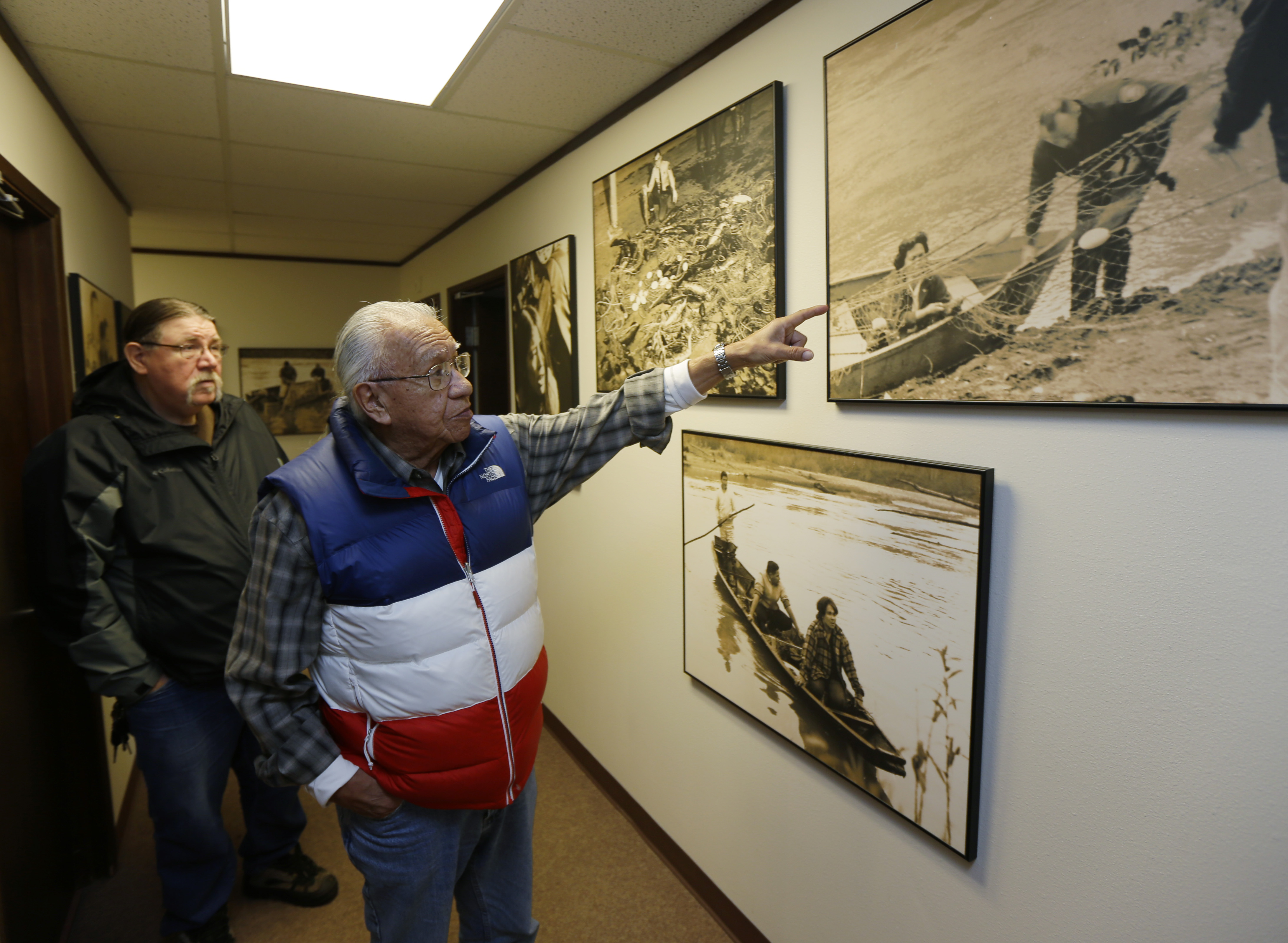 Indigenous elder Billy Frank Jr points to archival photos on the wall of the so-called "Fish Wars."