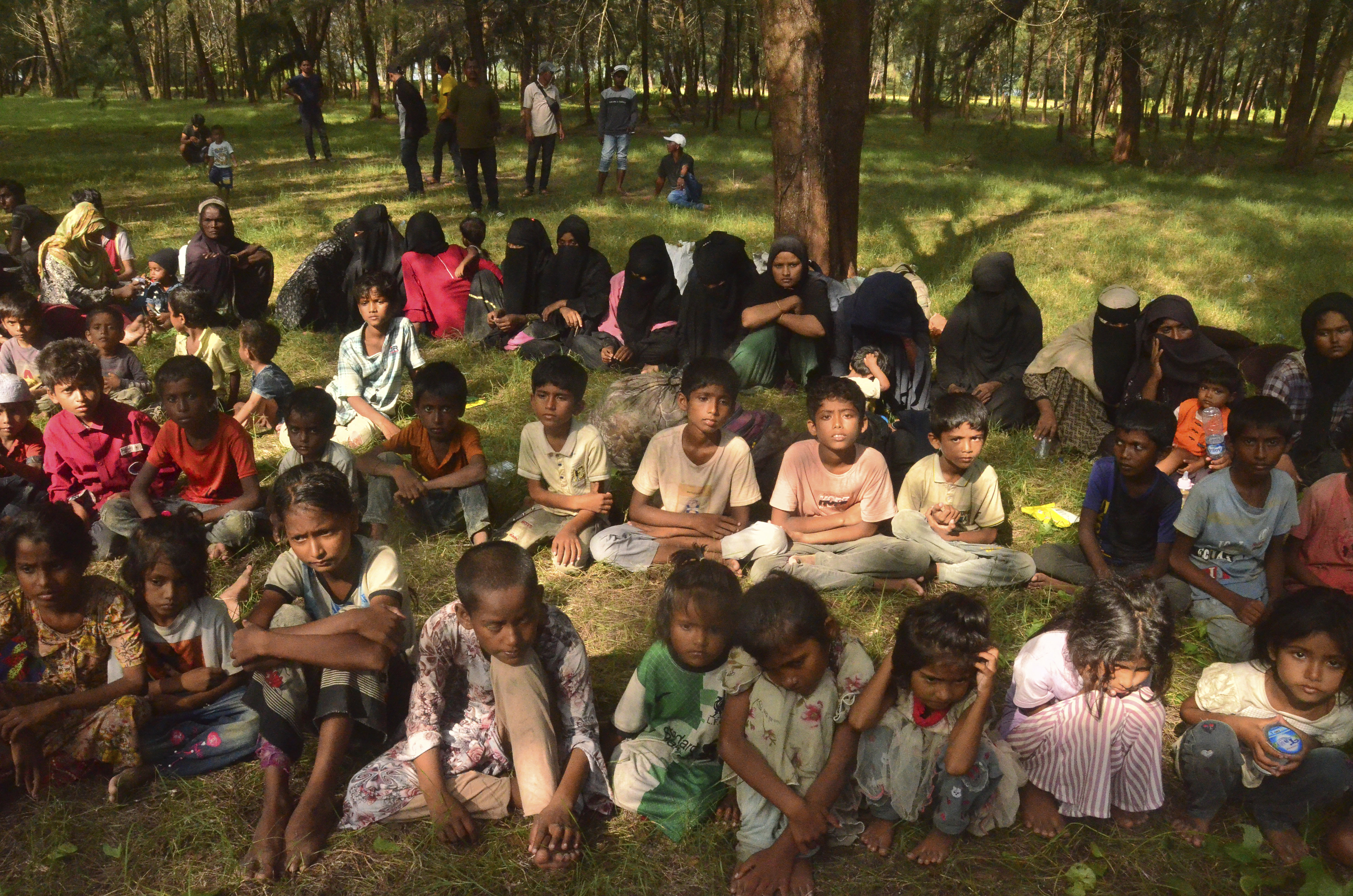 Ethnic Rohingya people sit on a beach after they land in Kuala Parek Beach, East Aceh, Aceh province, Indonesia, Thursday, Feb. 1