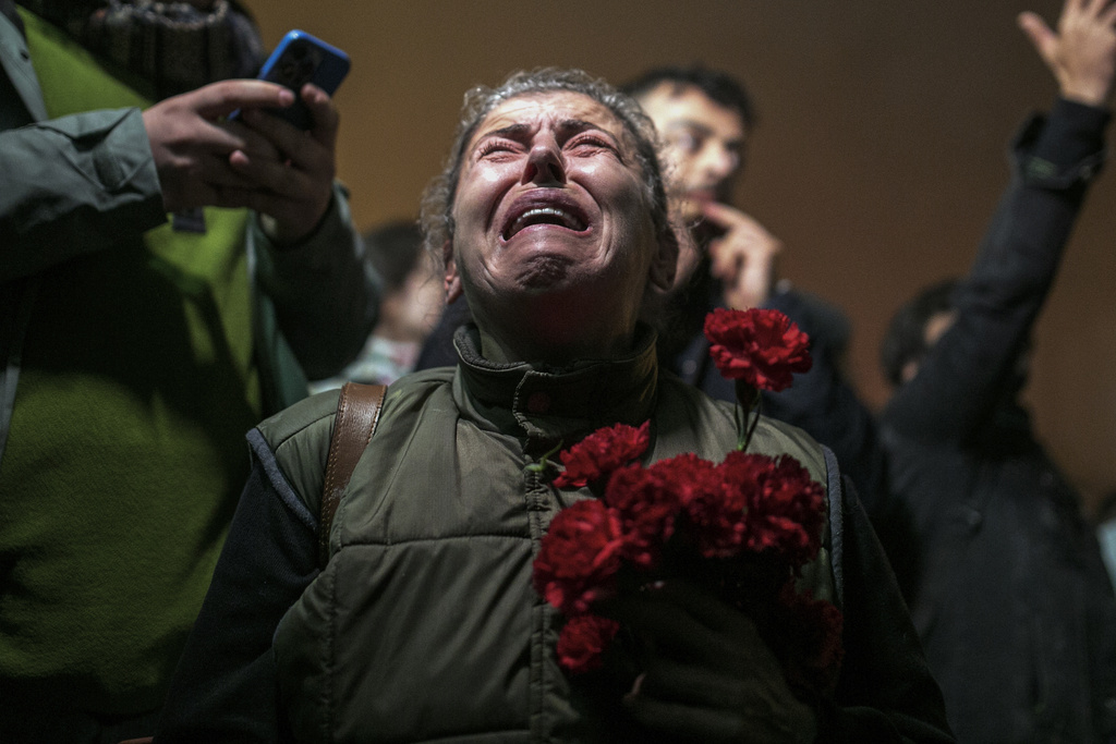 A woman cries as she and others gather in a moment of silence to mark the one-year anniversary of the country's catastrophic earthquake, in the city of Antakya, southern Turkey