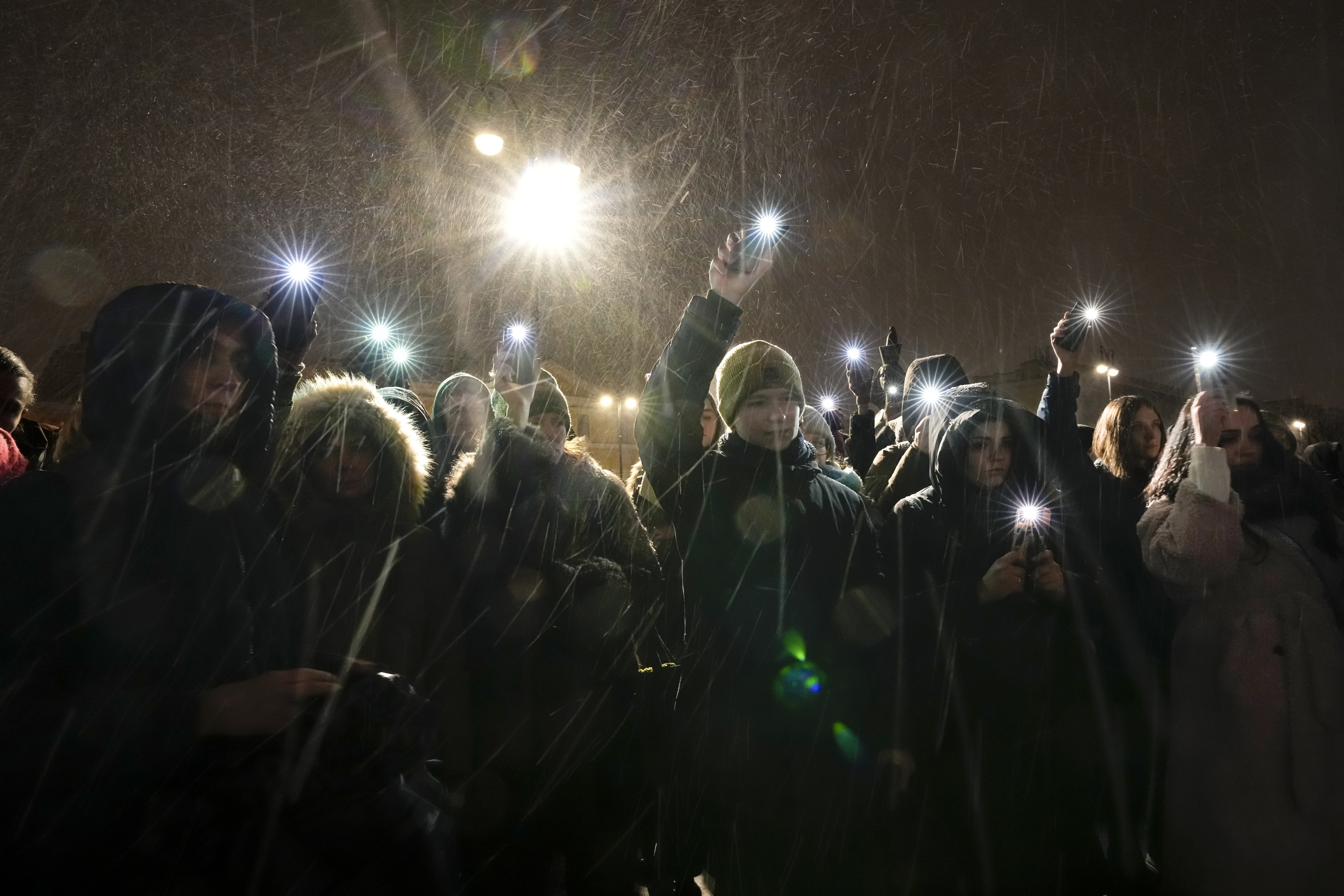 People wave their mobile phones with flashlights on as they pay their last respects to jailed Russian opposition leader Alexei Navalny at the Memorial to Victims of Political Repression in St. Petersburg, Russia on Friday, Feb. 16