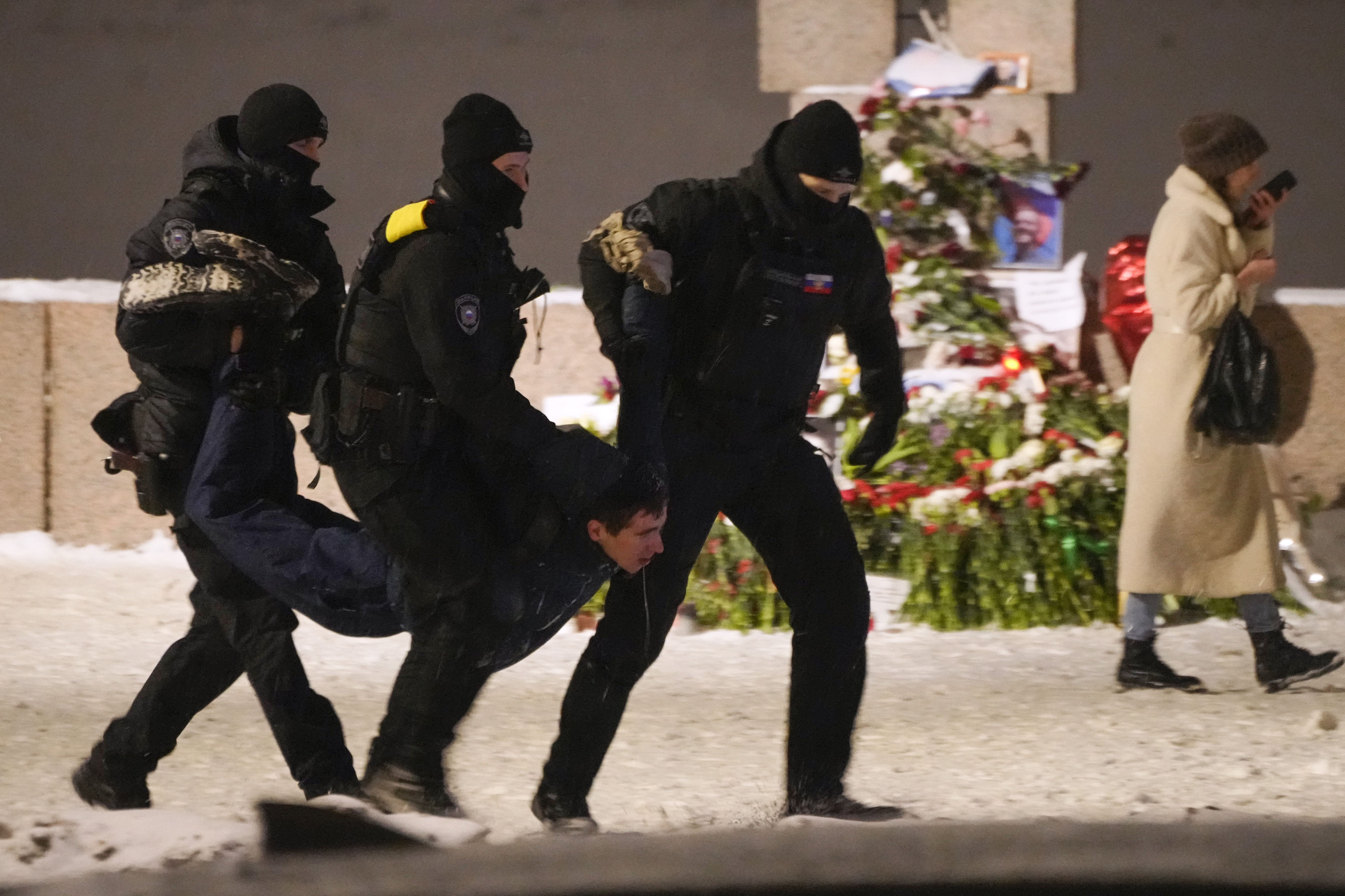 Police officers detain a man laying flowers to Alexei Navalny at the Memorial to Victims of Political Repression in St. Petersburg