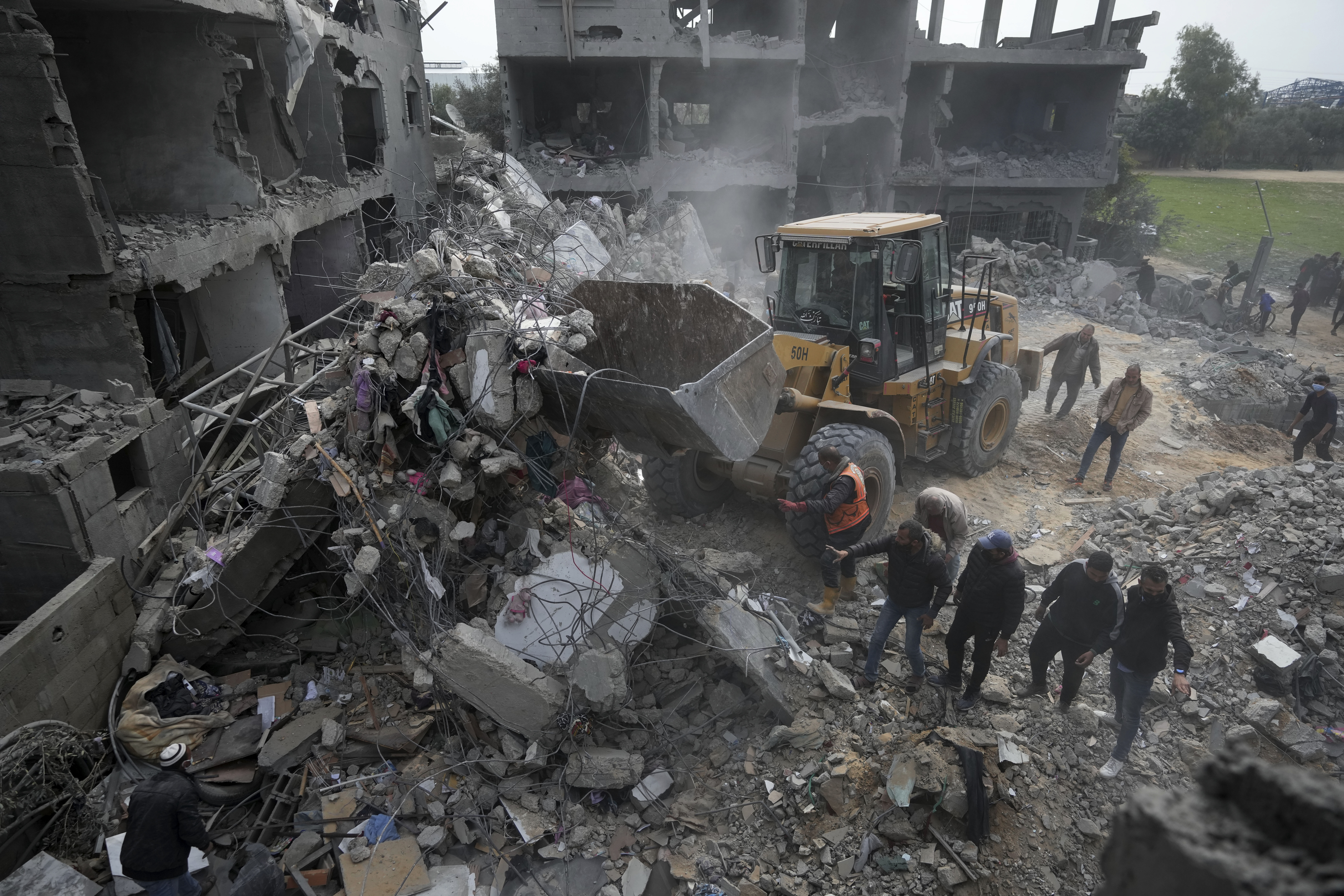 Palestinians search for survivors after an Israeli airstrike on a residential building of the Yaghi family in Deir al Balah