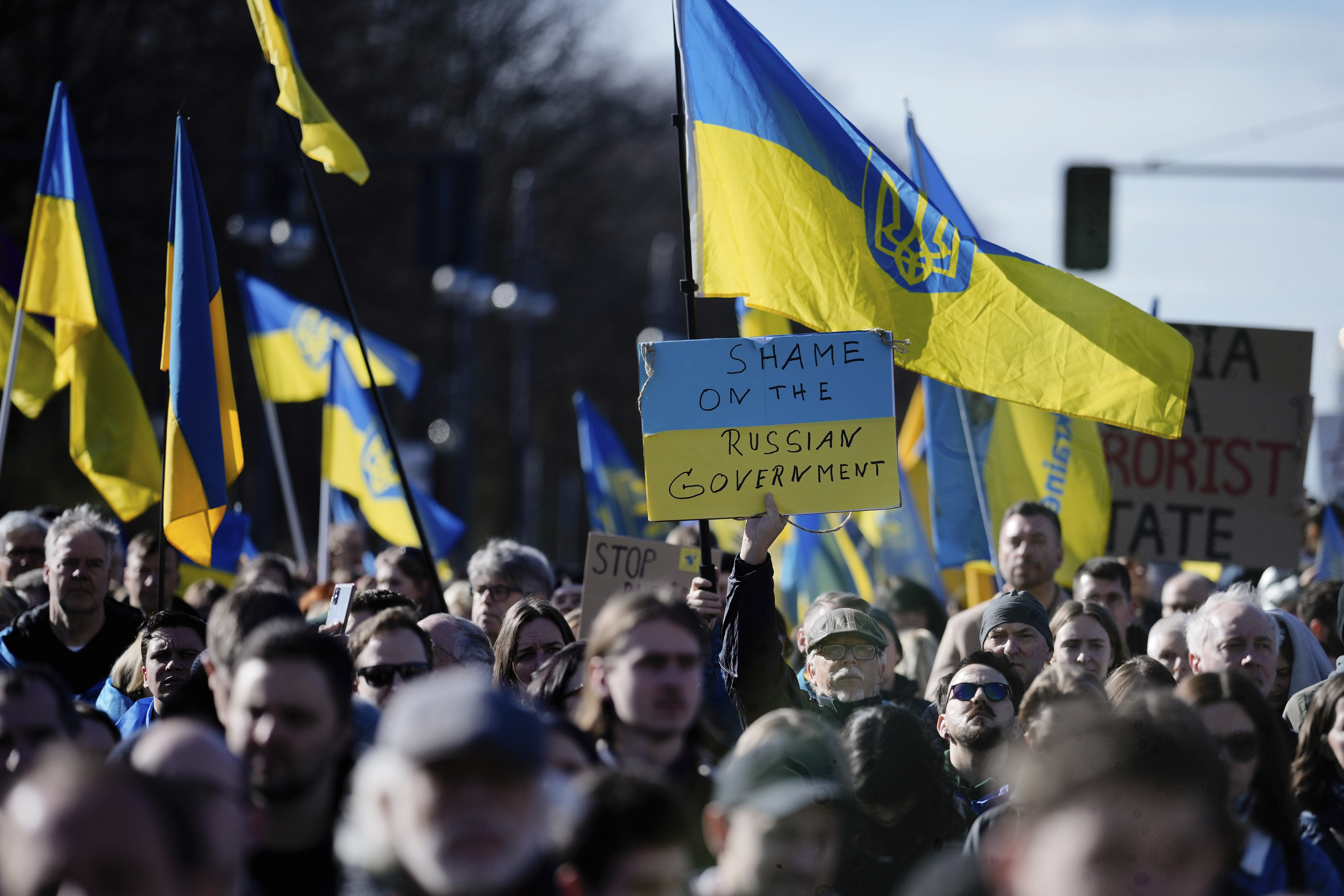 People hold posters and Ukrainian flags during a protest to mark two years since Russia's full-scale invasion on Ukraine, at the Brandenburg Gate, in Berlin, Saturday